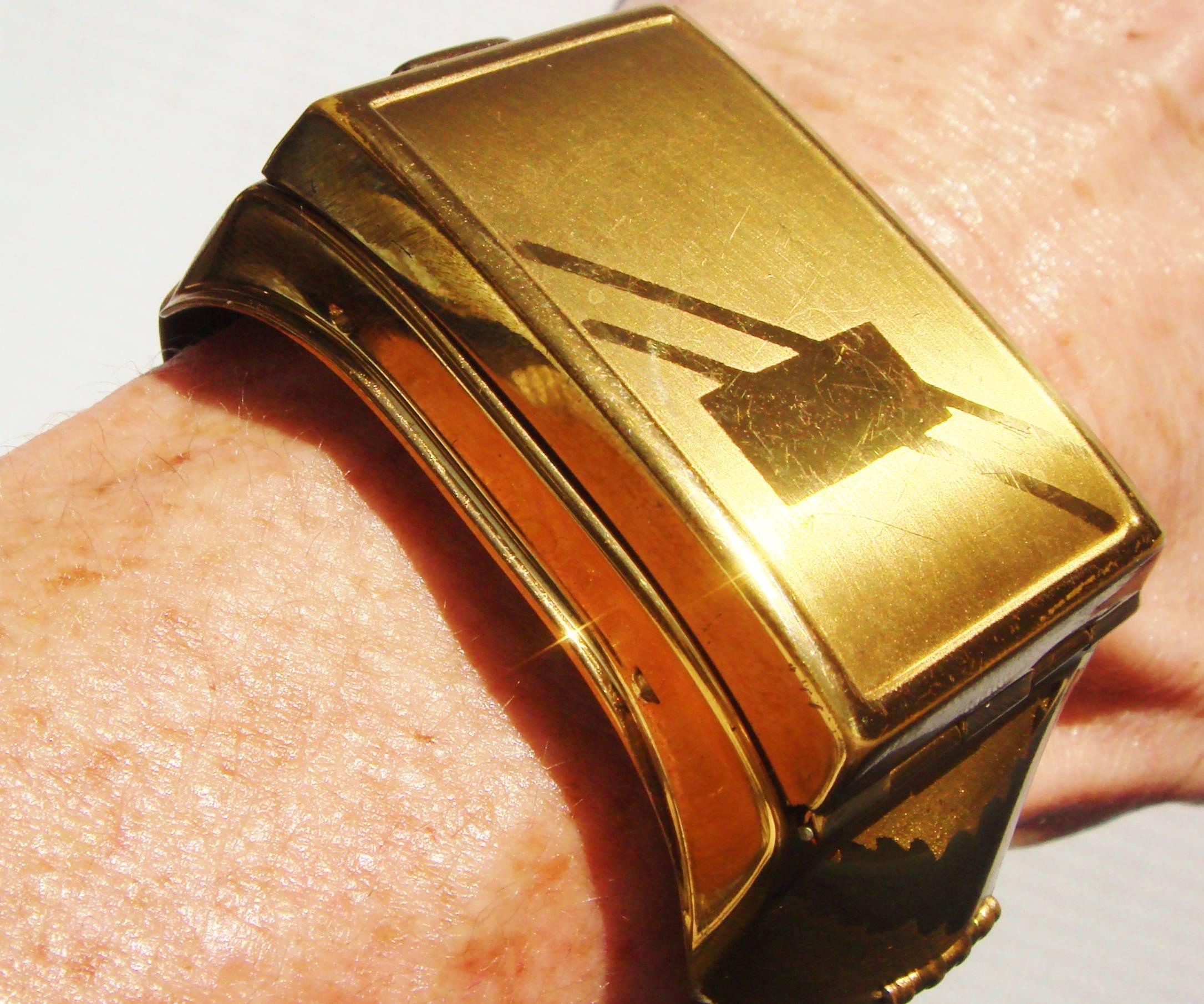 This very stylish and rare American Art Deco wrist compact clamper bracelet was manufactured by famed compact makers Kotler and Kopit Incorporated of Pawtucket, Rhode Island. It features a geometric faceplate with an unused monogram plaque. The