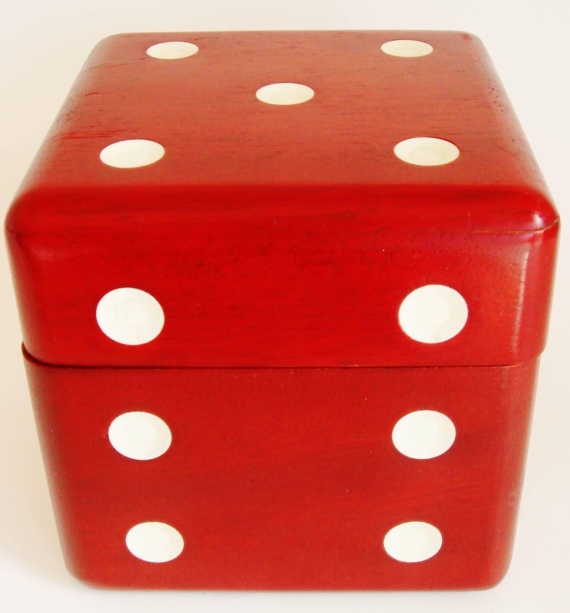 This eccentric Japanese Mid-Century Modern, six-piece liqueur/decanter set is housed in a giant wooden dice that is finished in a rich oxblood stain and inset with white Lucite pips. The lid is hinged with two brass hinges and opens to reveal a