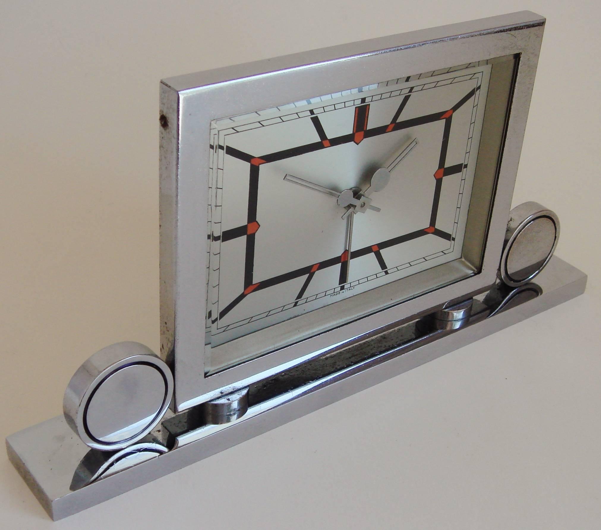 This very stylish Italian chrome-plated Art Deco mechanical alarm clock features a beautifully designed red and black geometric face. The Art Deco design of the hands is exceptional, the original chrome shows only very minor signs of age with no