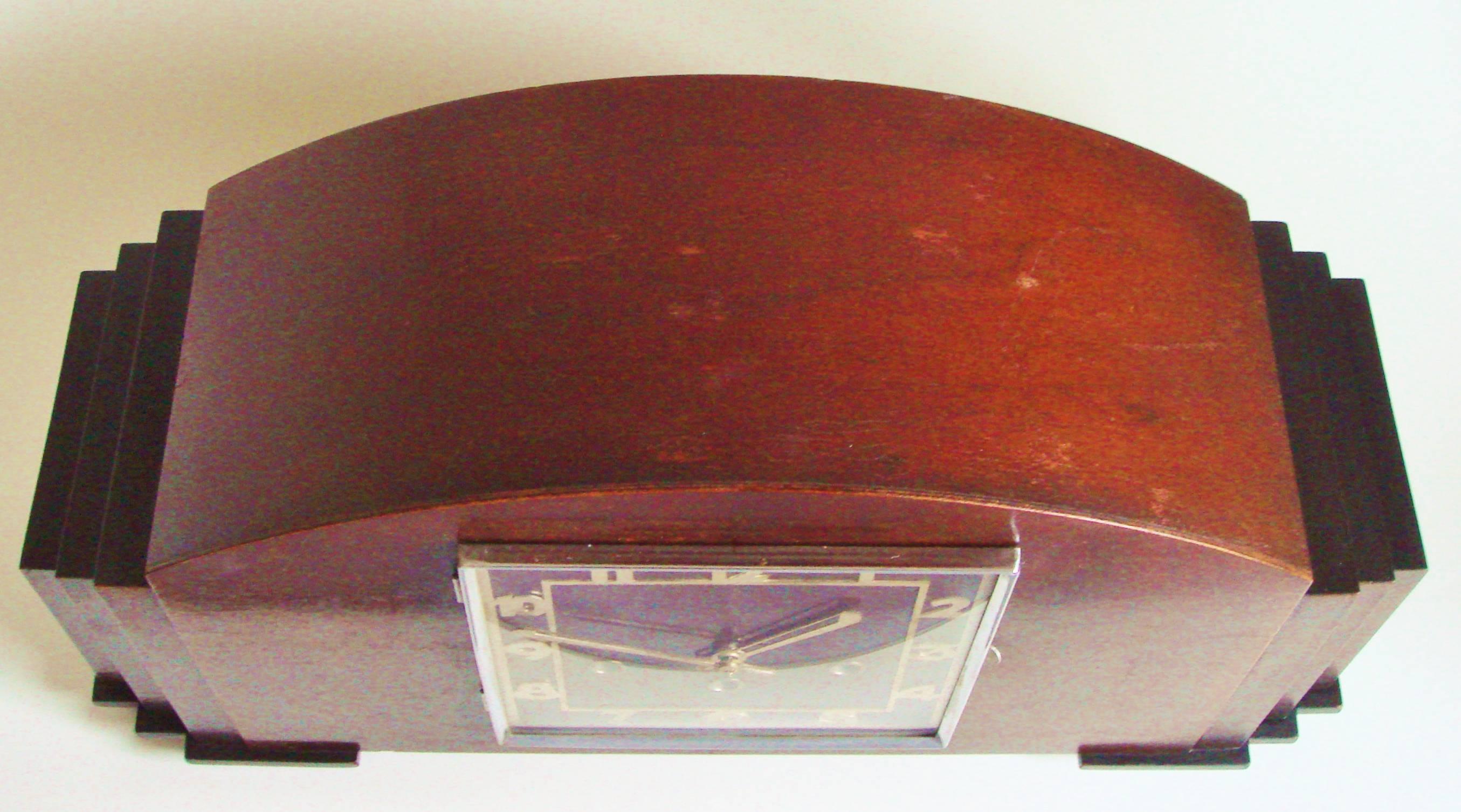 The design of this monumental architectural mantel clock has been attributed to the German clock making company Mauthe of Schwenningen and is a triumph of Art Deco design. The front of the arch-topped body of the clock is veneered in figured