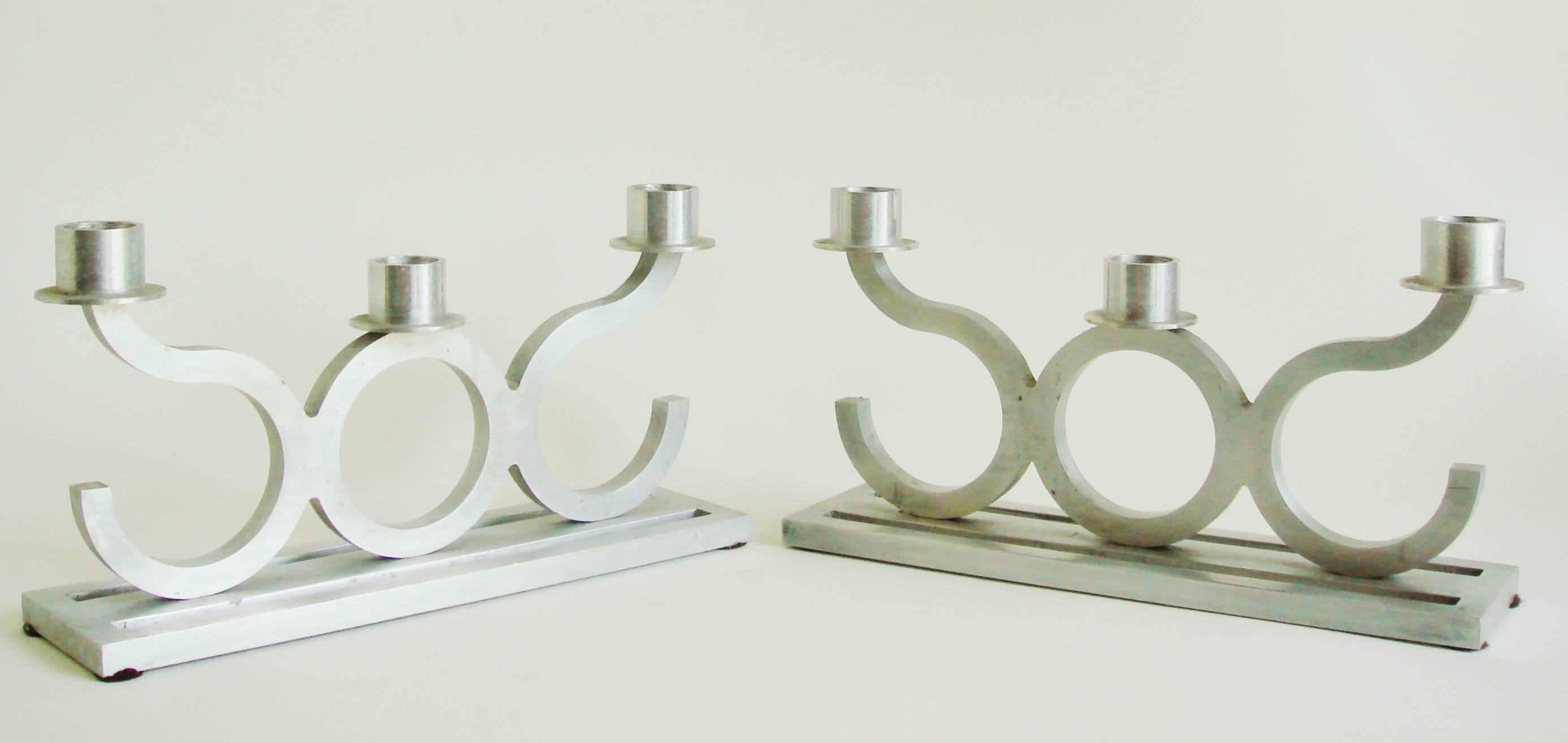 This pair of American Art Deco/Machine Age inline triple candle holders feature an oblong base cut from a sheet of 3/8