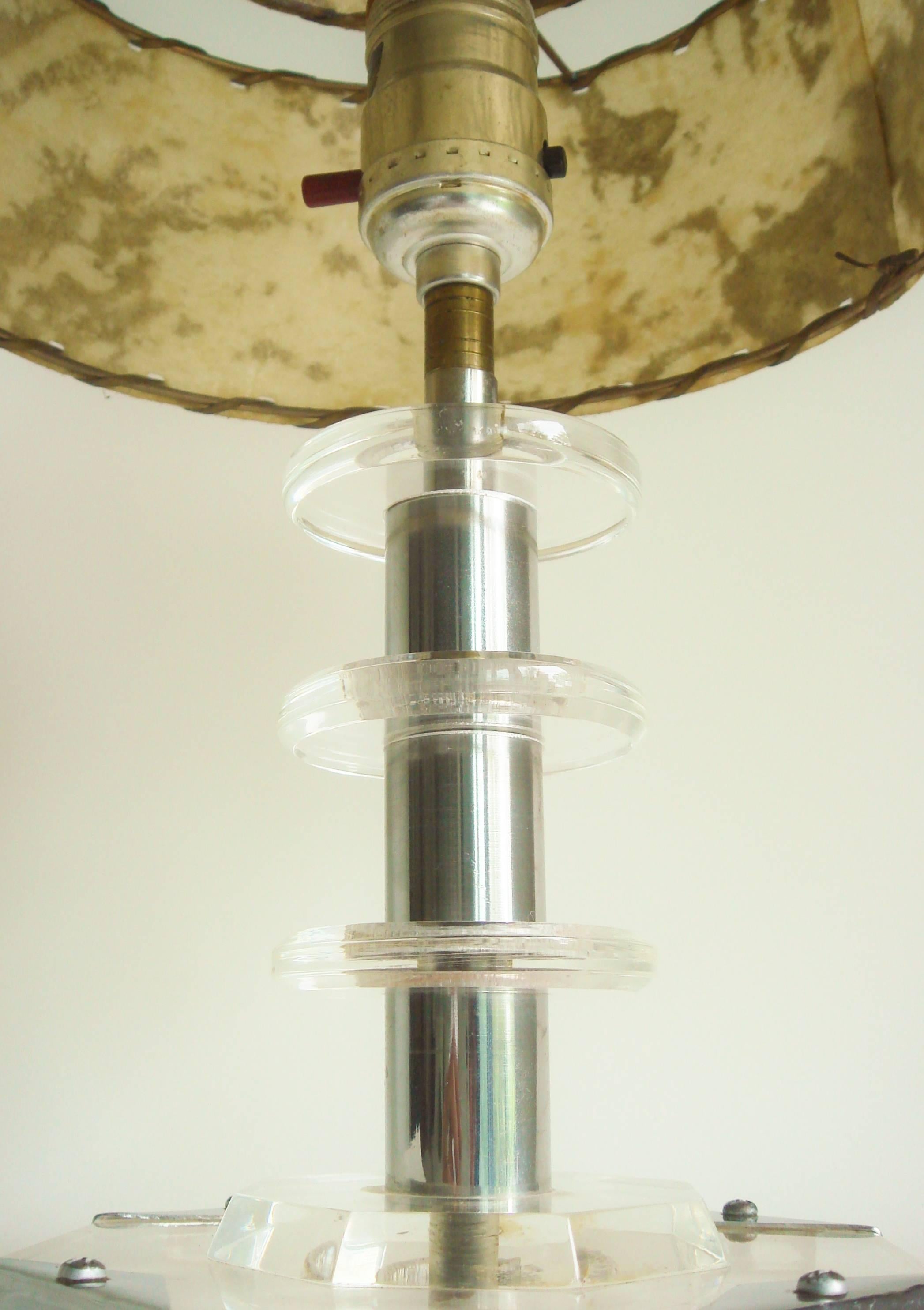 This beautiful Canadian late Art Deco clear Lucite and chrome table lamp features an octagonal beveled clear Lucite base that sits on four square Lucite feet that are in turn anchored by polished chrome triangle brackets affixed with screws. (These