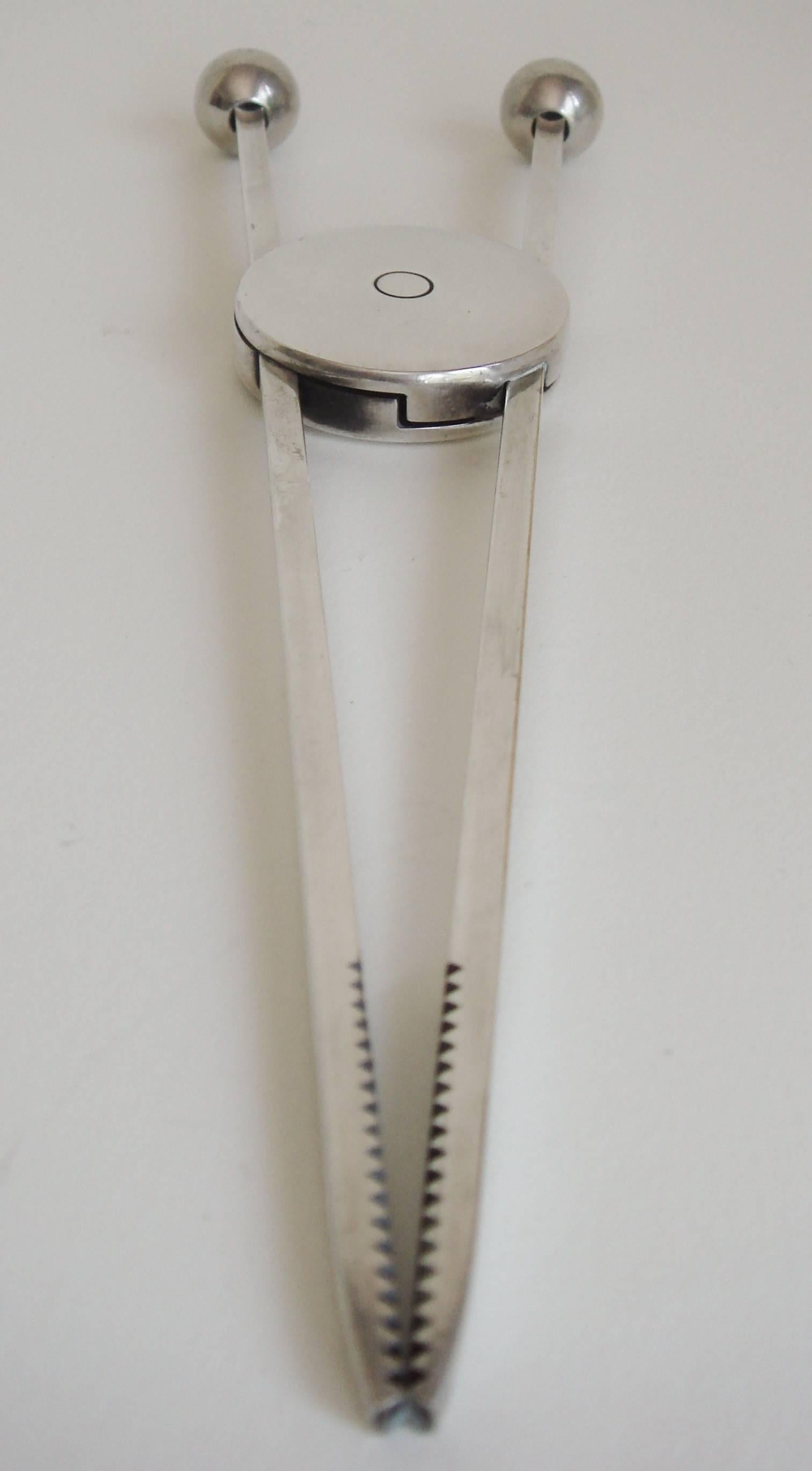 This beautifully designed pair of Mid-Century Modern, silver plated and sprung ice tongs is the work of the fabled French designer, Jacques Adnet. The disc shaped center portion houses a spring mechanism while the arms are each topped at one end