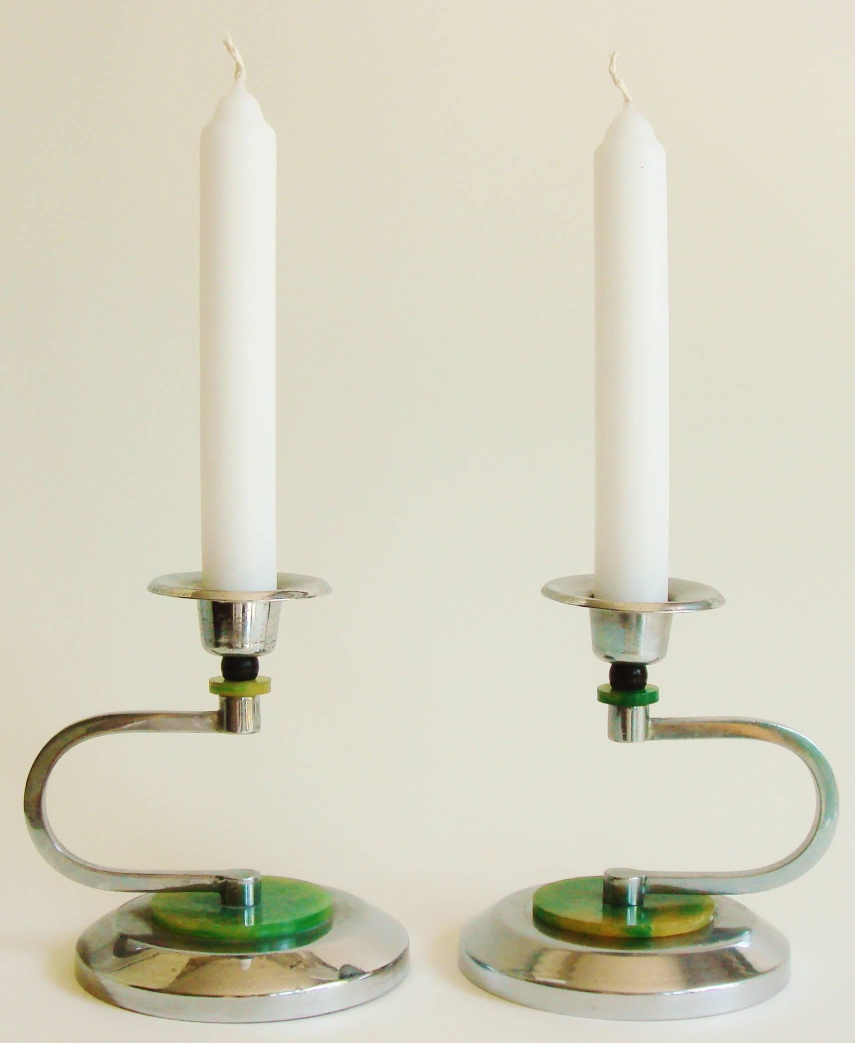 This pair of English Art Deco candlesticks feature circular chrome beveled edge weighted bases that are each capped with a bakelite disk marbled in green and yellow. The horizontal 
