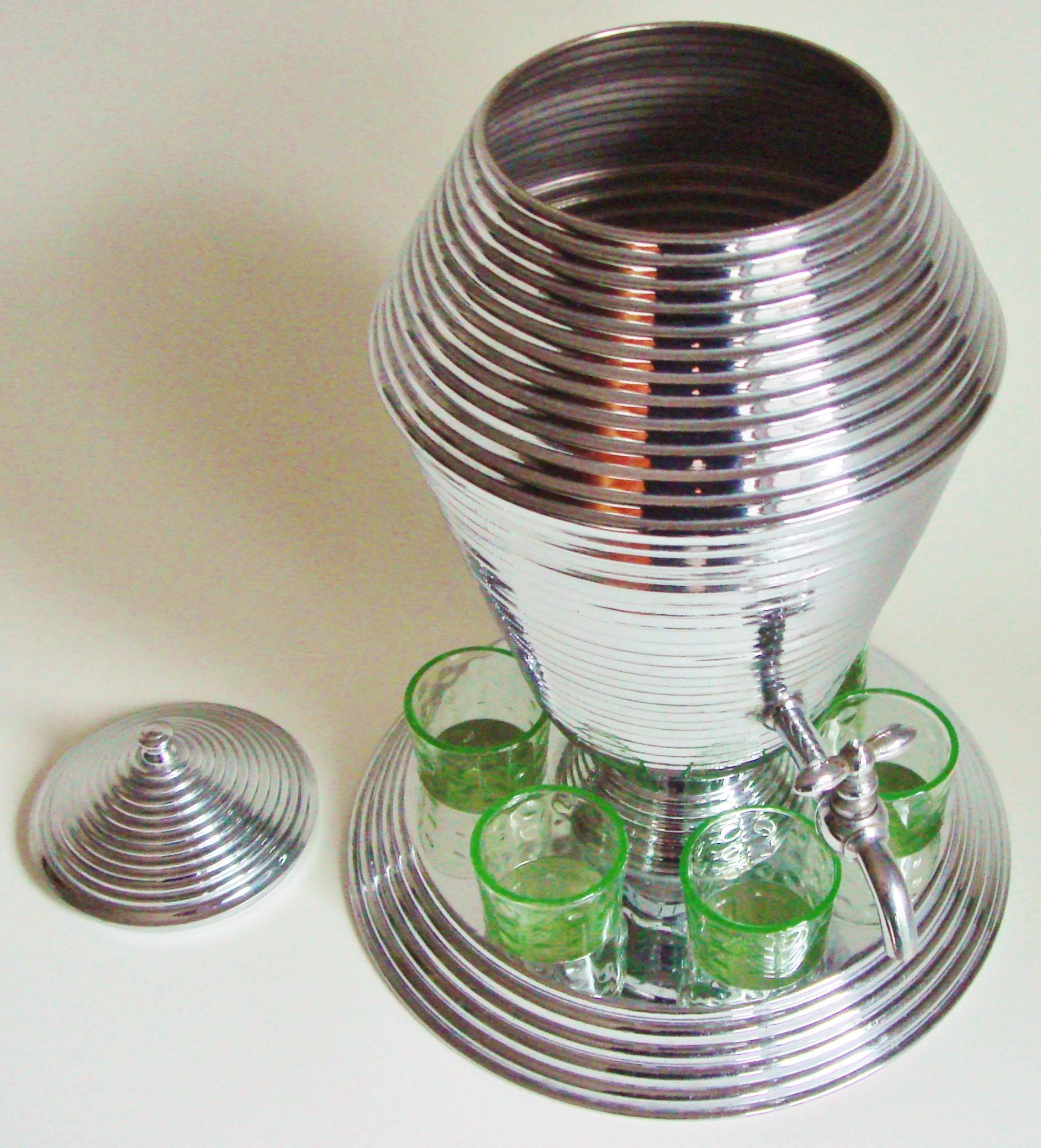 This distinctively styled American Art Deco seven-piece liqueur set is comprised of a beehive-ribbed; chrome-plated dispenser with a chrome spigot and mounted on a circular stepped base. This base is pierced with circular holes around the dispenser