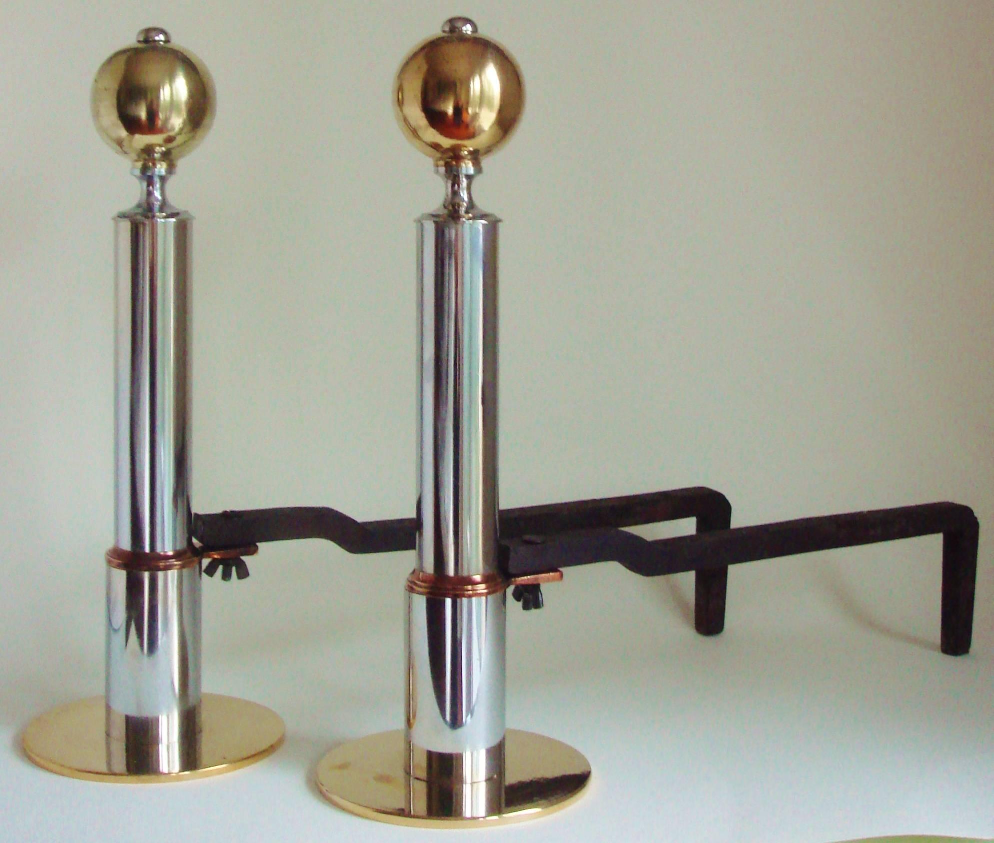 This pair of American Art Deco andirons have been totally restored and feature a 6" diameter brass disk base that supports a two-tier chrome column with the tiers separated by a copper ring. The columns are topped with a 3" brass sphere