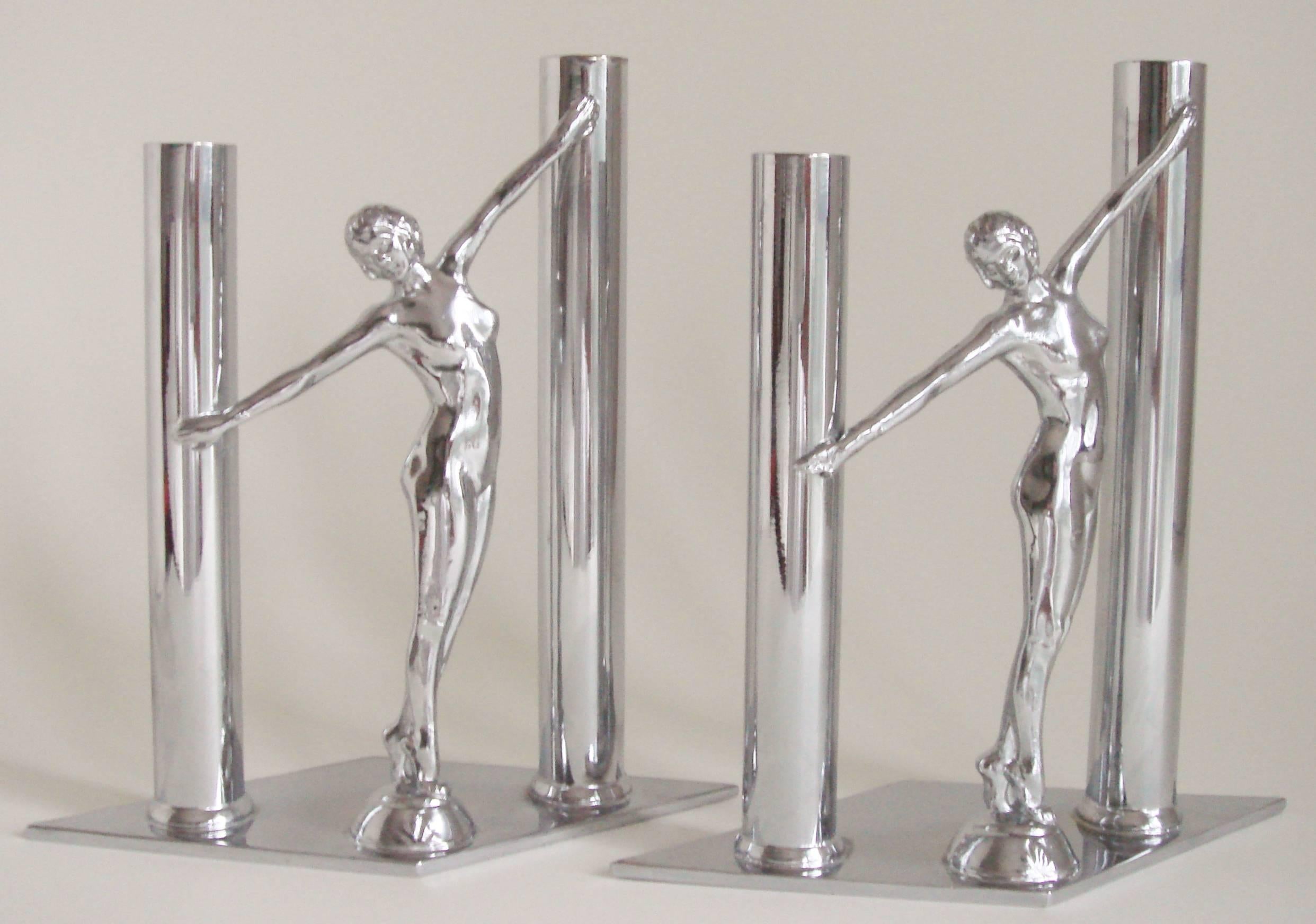 This elegant pair of American Art Deco chrome-plated figural bud vases feature two tubular vases of different heights either side of a female nude with arms outstretched. These figures each stand on small pedestals with a floral design and these in