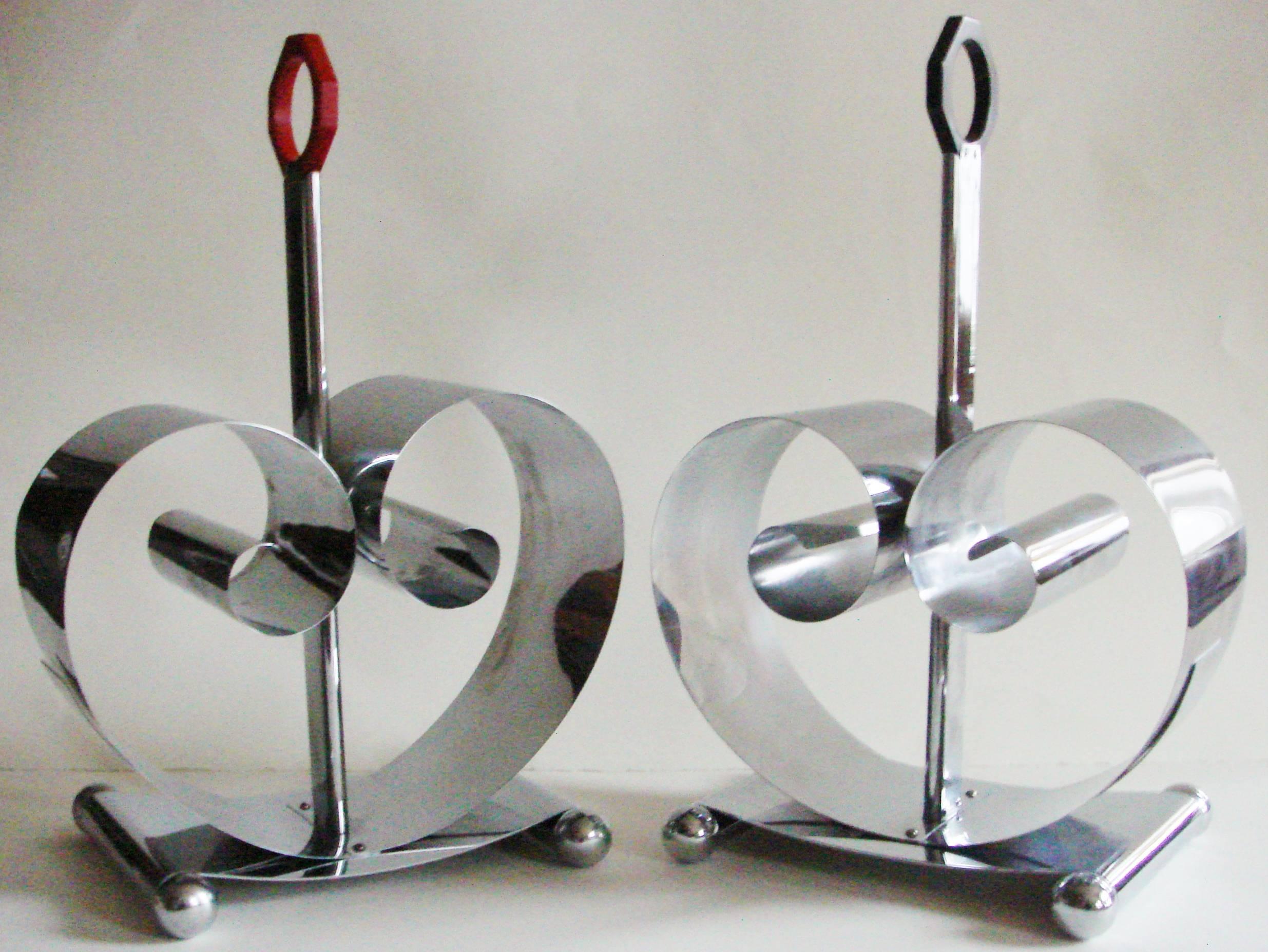 This stunning pair of American Art Deco chrome with red and black bakelite handles magazine racks were designed in 1934 by Fred D.Farr for Revere Copper and Brass Inc. of Rome, NY and appeared in their 1935 catalogs. Both items are marked with the