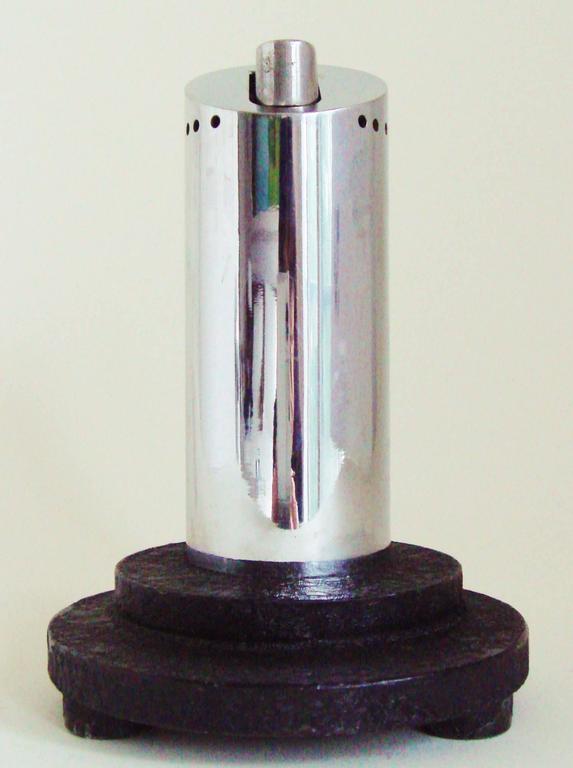 This unusual English Art Deco chrome and black wrinkle paint, wheel and flint table lighter features an asymmetrical and architectural design. The body of the lighter is a chrome-plated pillar that is sliced off at an angle at the top and at the