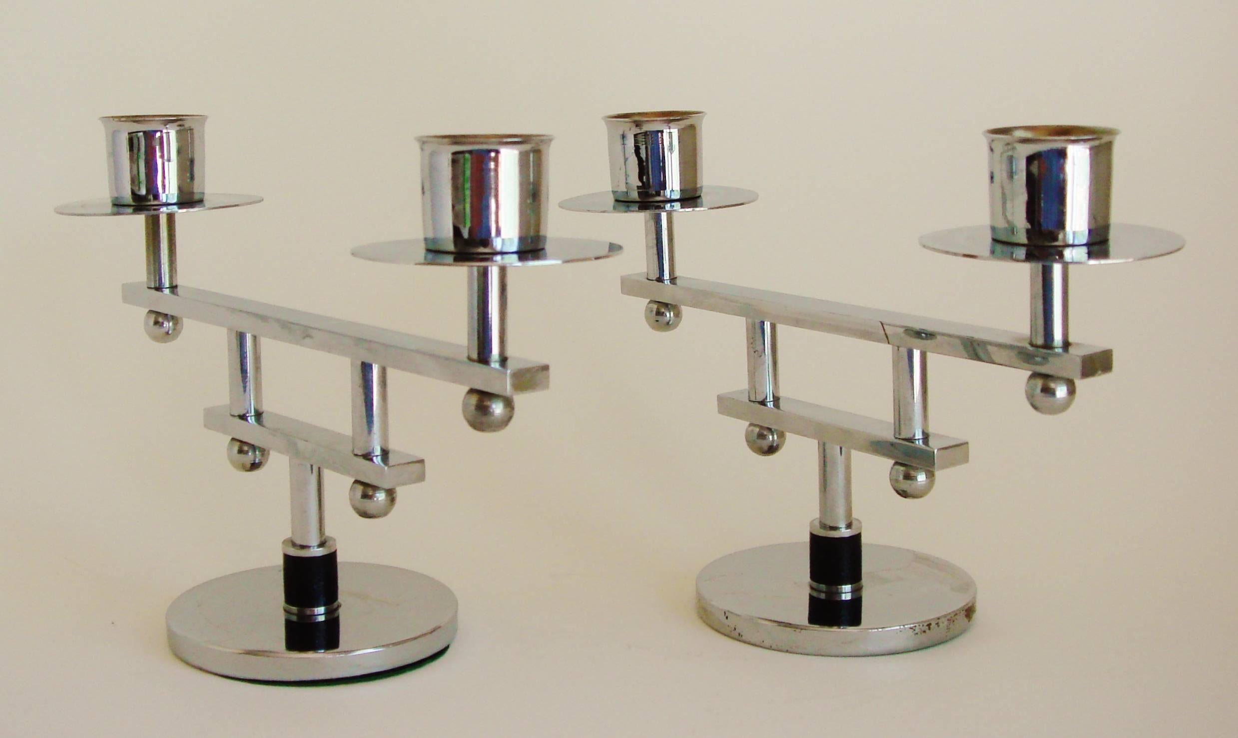 This pair of English Art Deco chrome and black Bakelite architectural twin candleholders have an almost Japanese design aesthetic. The candle sockets are attached to a beam and sphere support which is in turn mounted to a disk base by a chrome rod