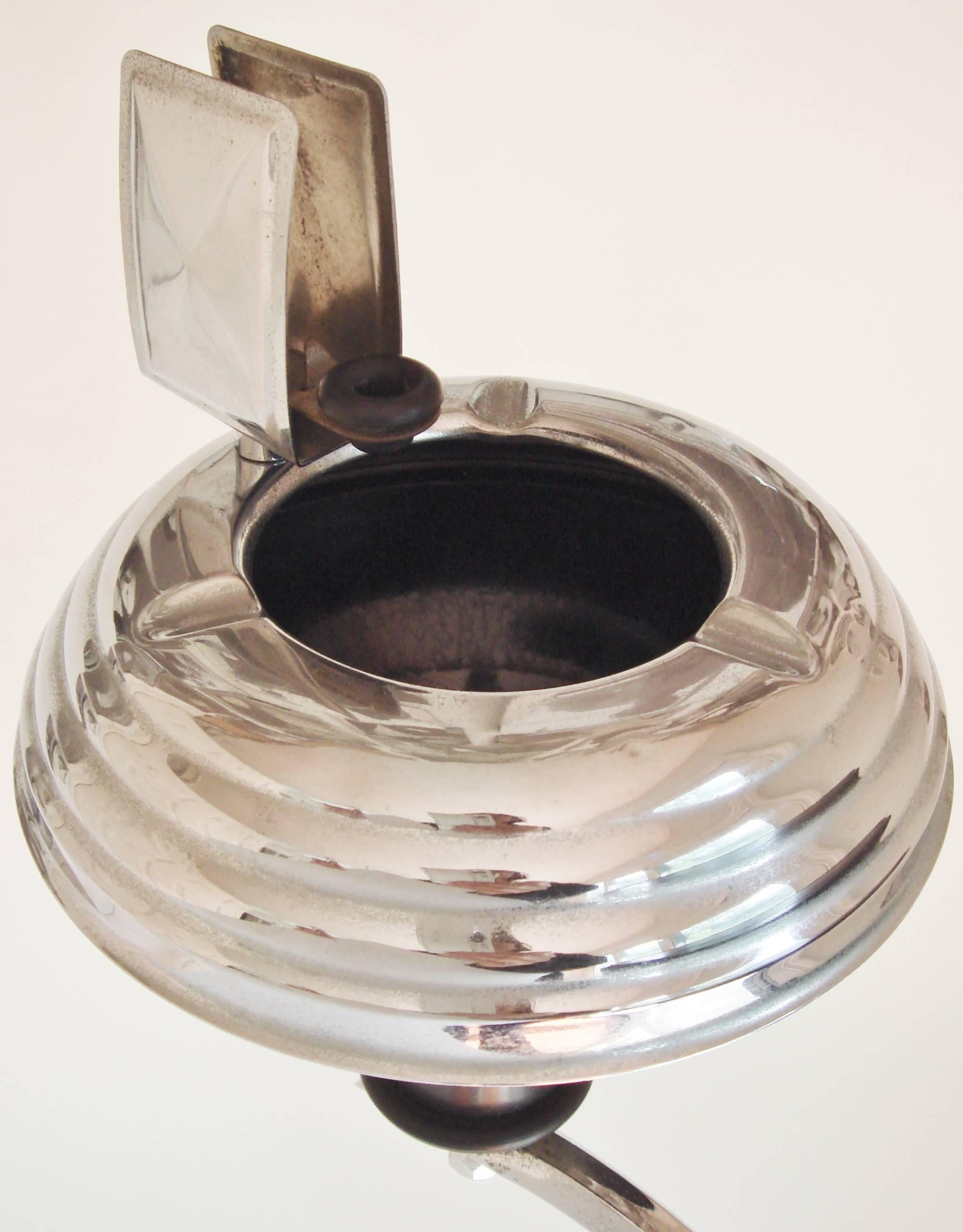 This stylish Art Deco combination smoker's table, ashtray, matchbook holder and cigarette stubber was manufactured by Arrow Metal Products of Australia. It features a ribbed circular chrome cushion base with a black knop that supports two chrome
