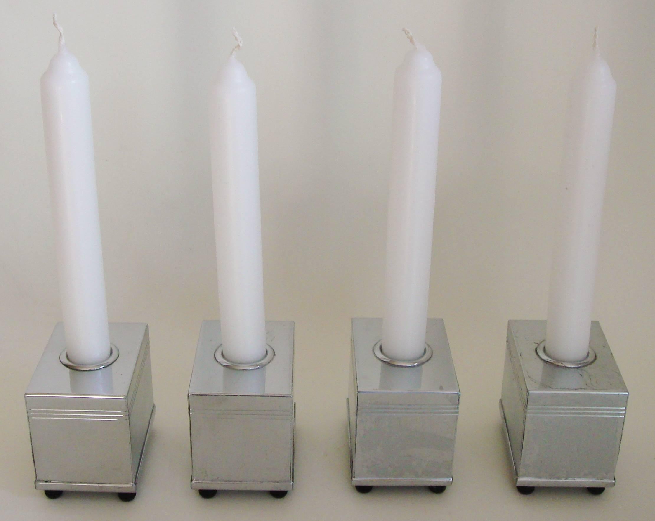 These four rare American Art Deco chrome-plated and banded block candlesticks each stand on four ribbed and black painted, bun feet. They form part of the innovative Architex centrepiece set designed in 1934 (see patent below) by Lurelle guild for