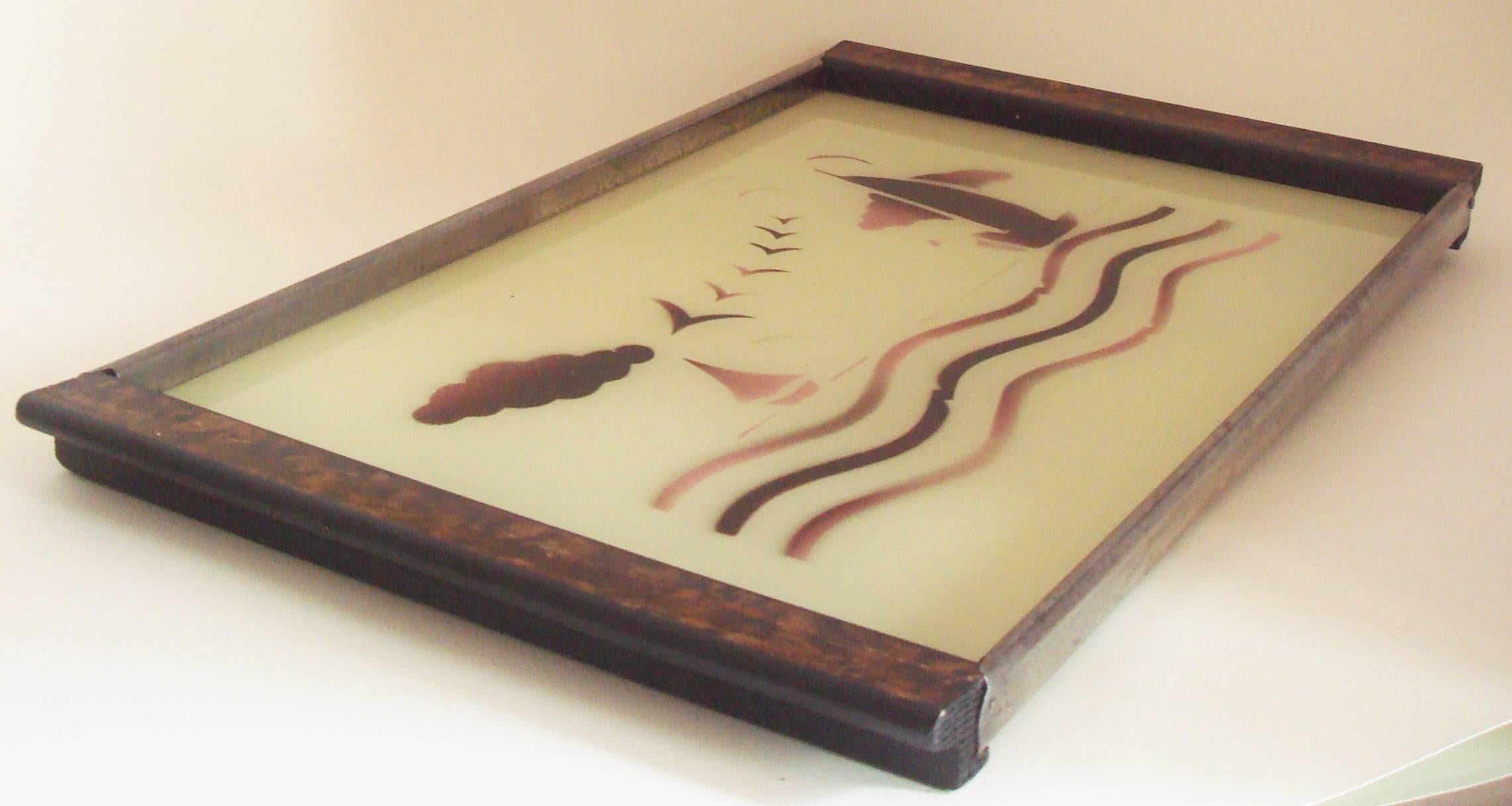 The design of this German Bauhaus Spritzdekor (or airbrushed) cocktail tray is unusual as it features a stylized figurative seascape with yachts and seabirds whereas the majority of Spritzdekor items have abstract patterns. This reverse painted