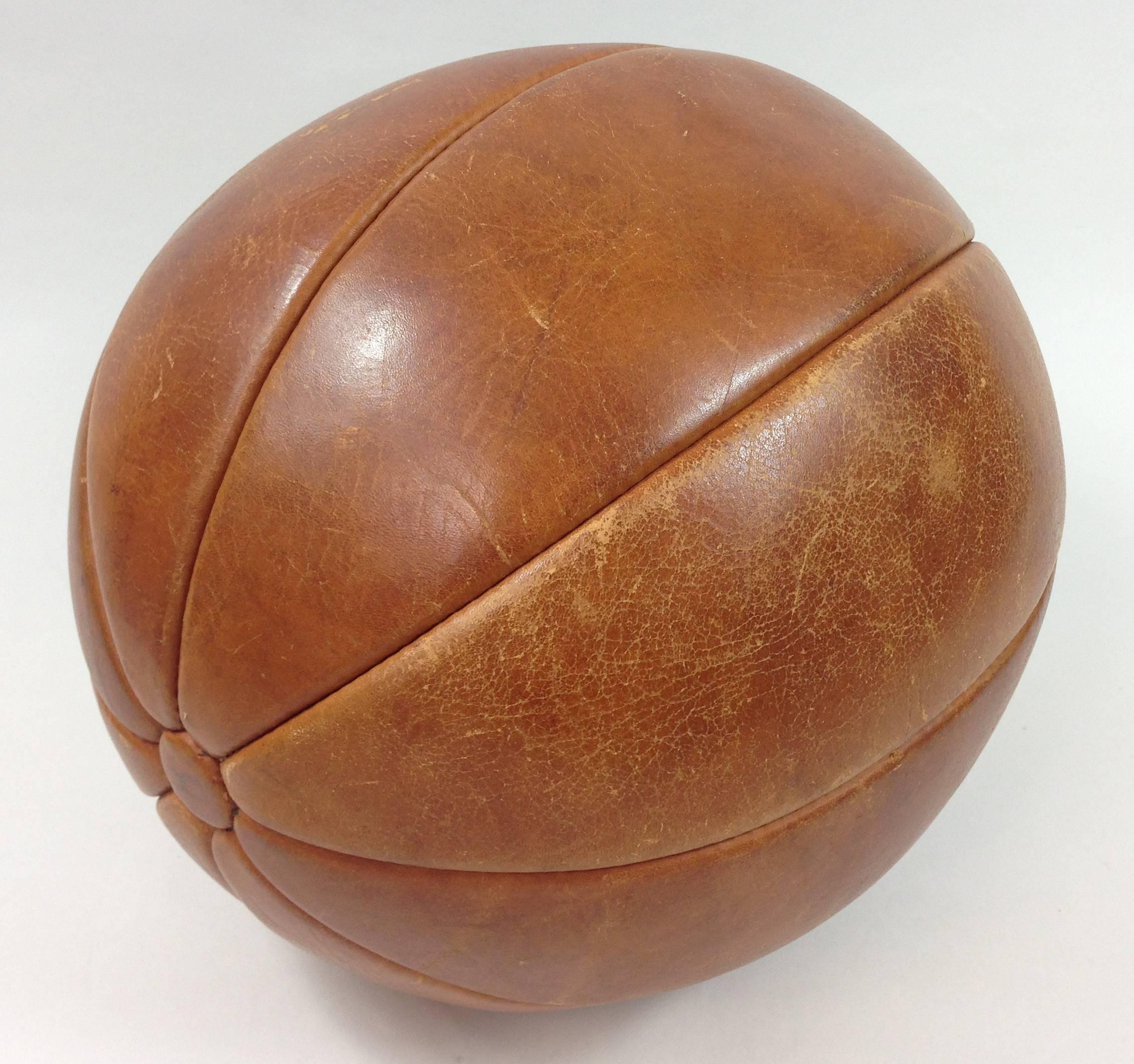 A large mid-20th century leather gymnasium medicine ball.

Constructed of eight stitched panels. Good condition for it's age with obvious signs of wear and use.

Most probably English.

   