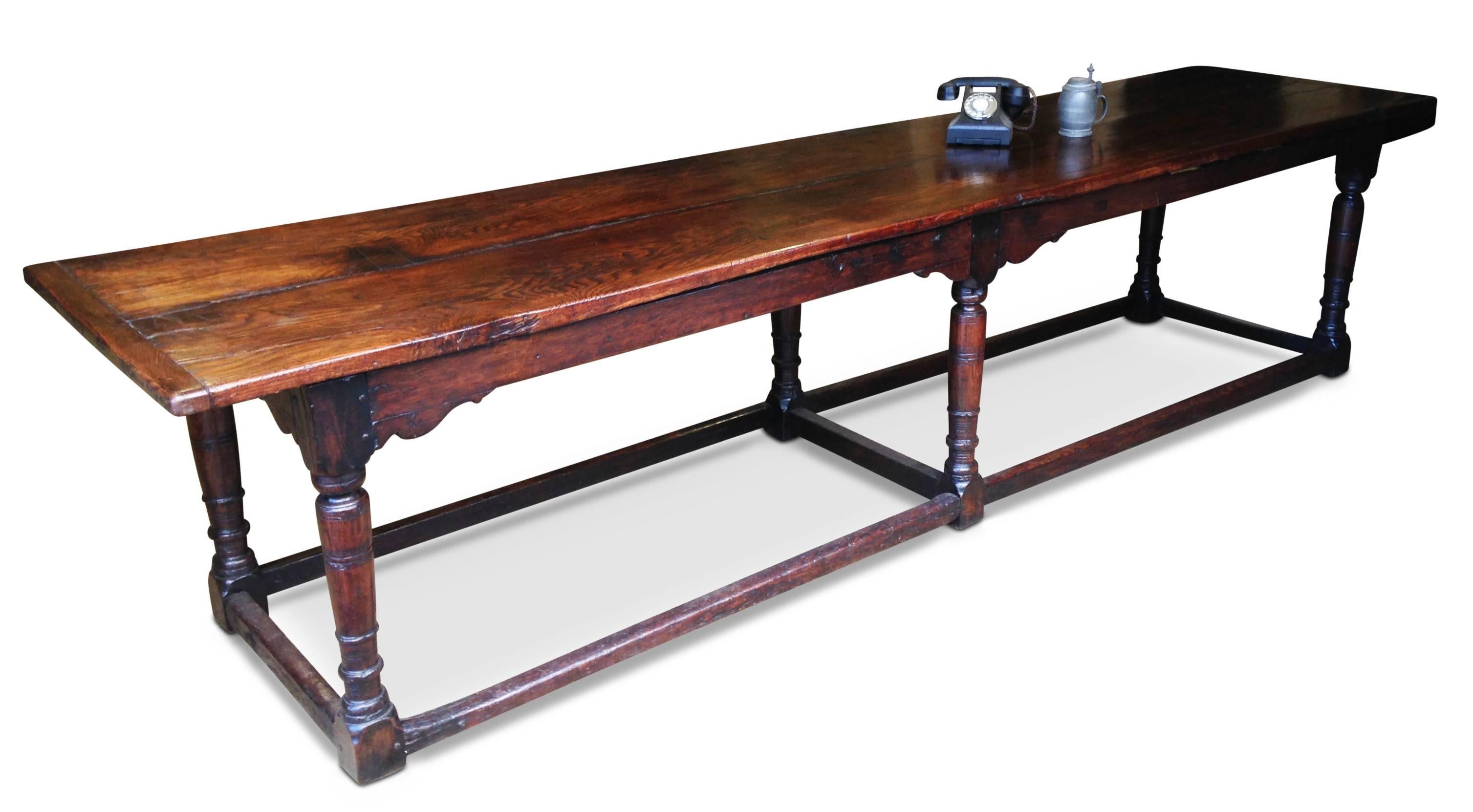 A very large 17th century oak refectory table.

The removable two-plank top sits upon six turned legs with spandrels, joined at the foot by stretchers. The underside of the top has later support boards which are not visible when the table is in