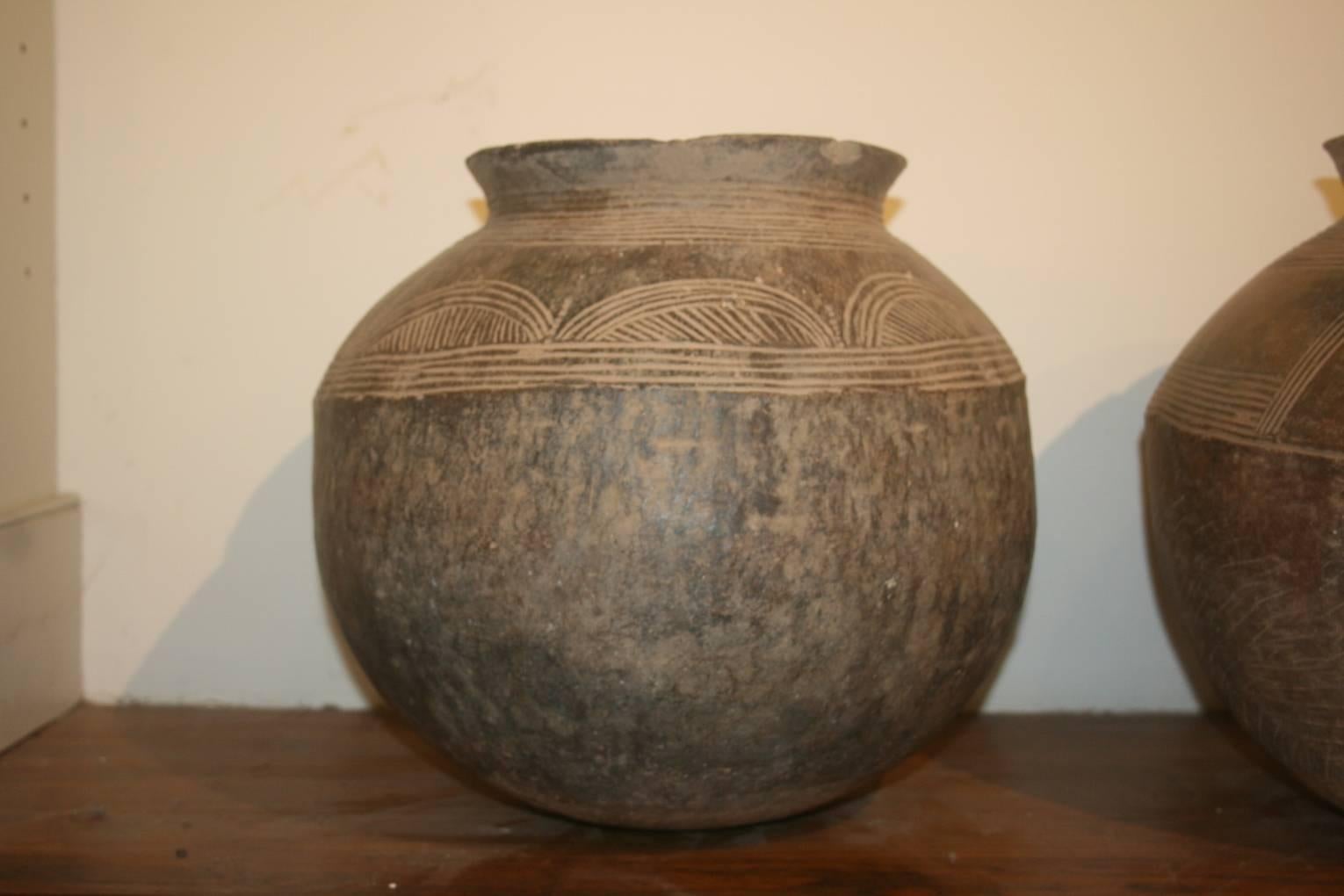 Pair of ceramic vessels from the Ivory Coast of Africa known as Baule pots. The scale and proportions are beautiful. There are incised designs on each one. They are handmade by the women of the village and were mostly used to hold water. The women