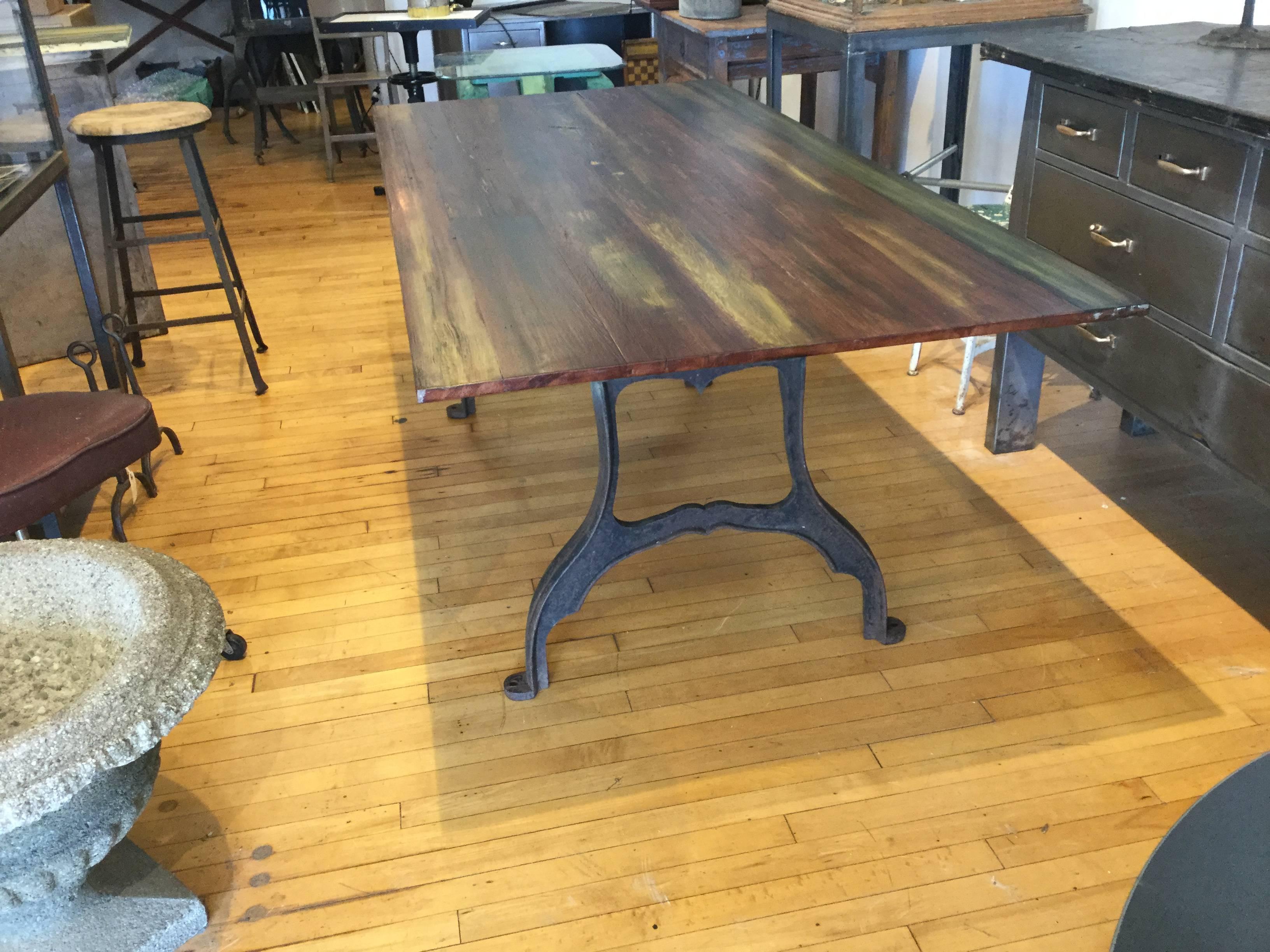 Industrial 19th century cast iron base dining or work table or desk. Redwood top made from 19th century NYC water towers. The redwood had absorbed minerals and chemicals from the water over one hundred years that left gray greens and dark reds . A