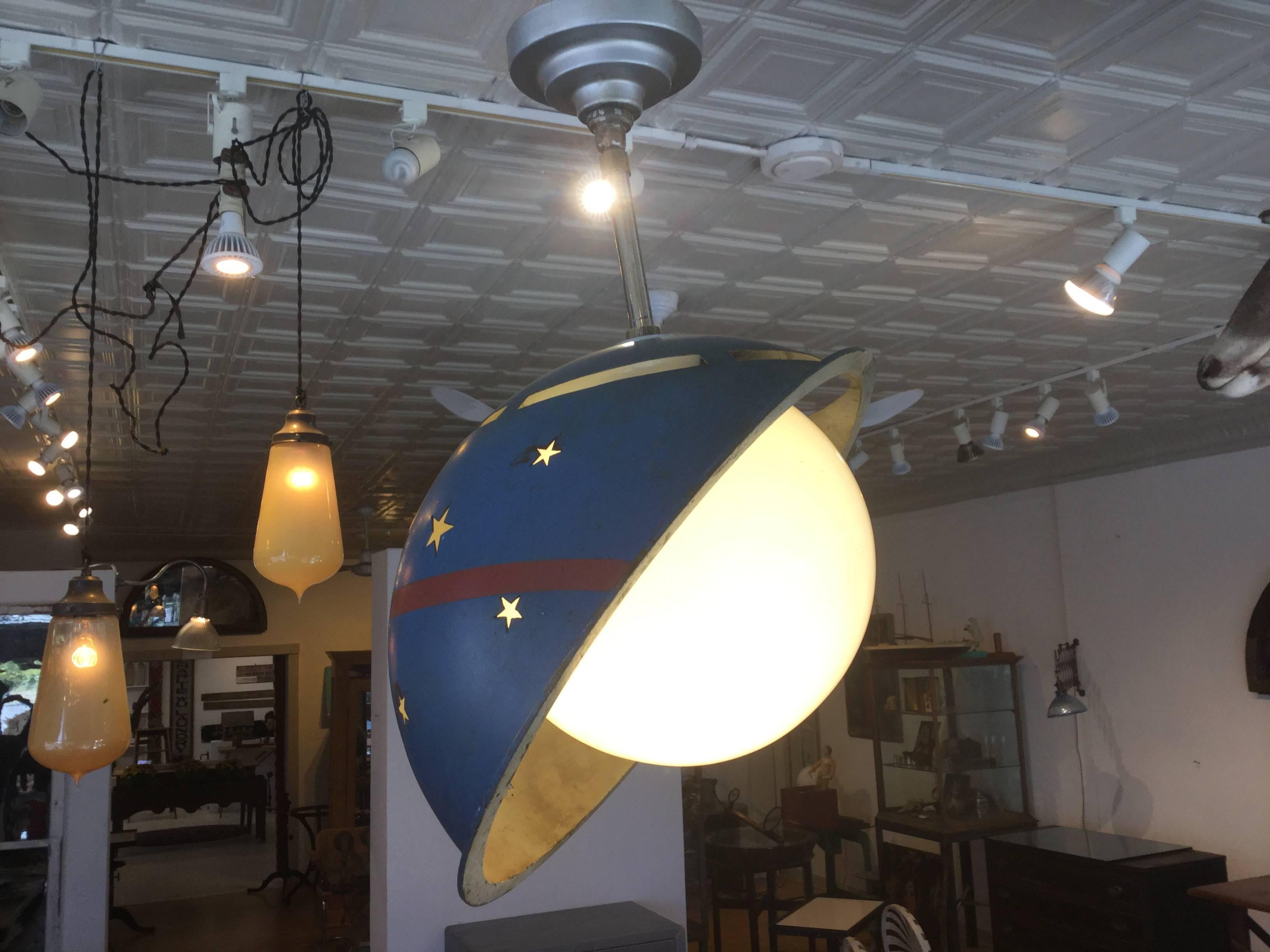 Hanging moon and stars Lamp. Blue painted Saturn shaped helmet made of steel surrounds a glass globe or moon. The stars are cut-out. All original paint. New wiring. Hangs about 8 inches from the ceiling.