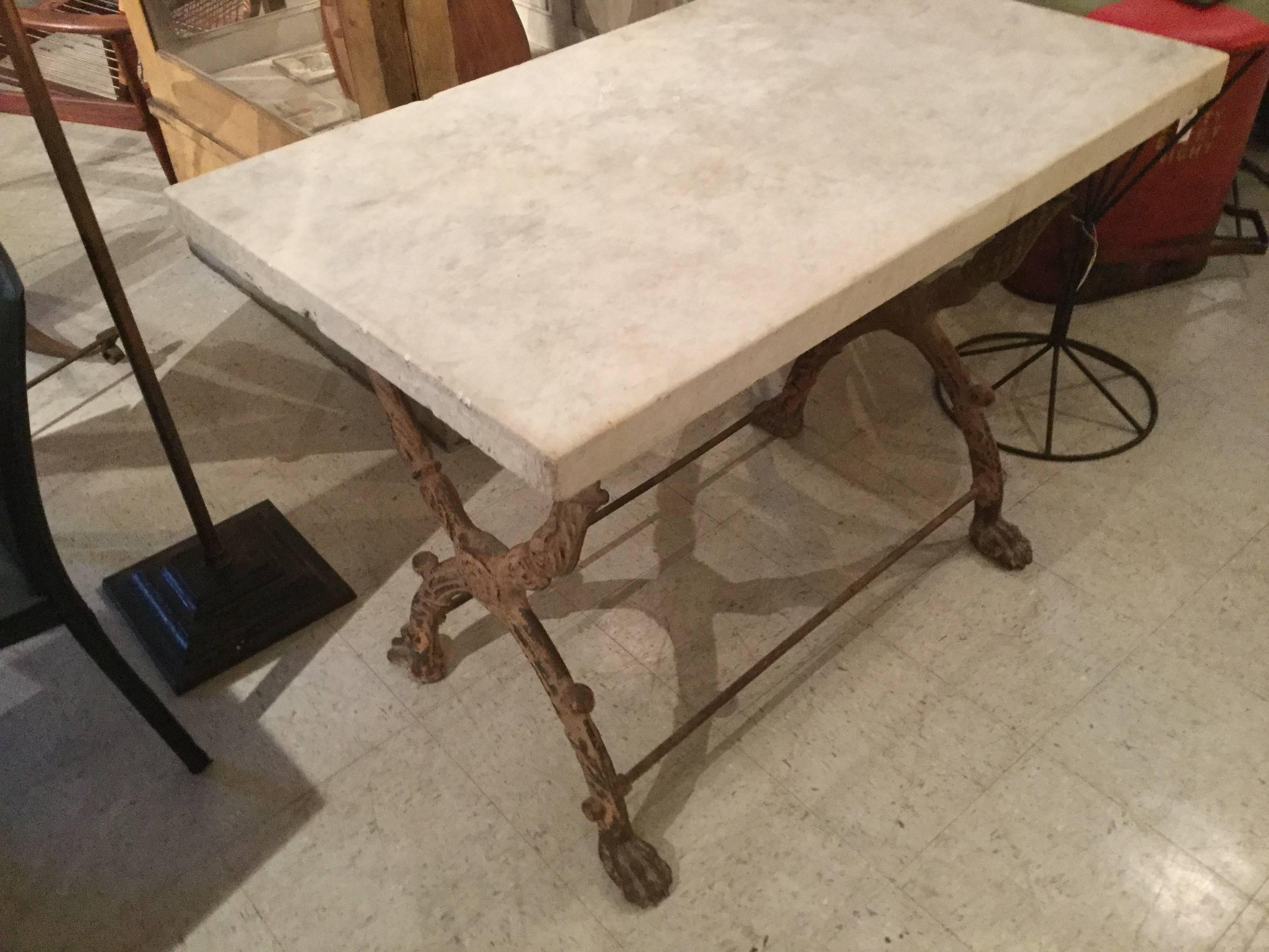 French garden table with 1 3/4 inch think marble top. Cast iron base with lion feet has original salmon color paint. The table has beautiful proportions and would look great in the best garden or indoors.