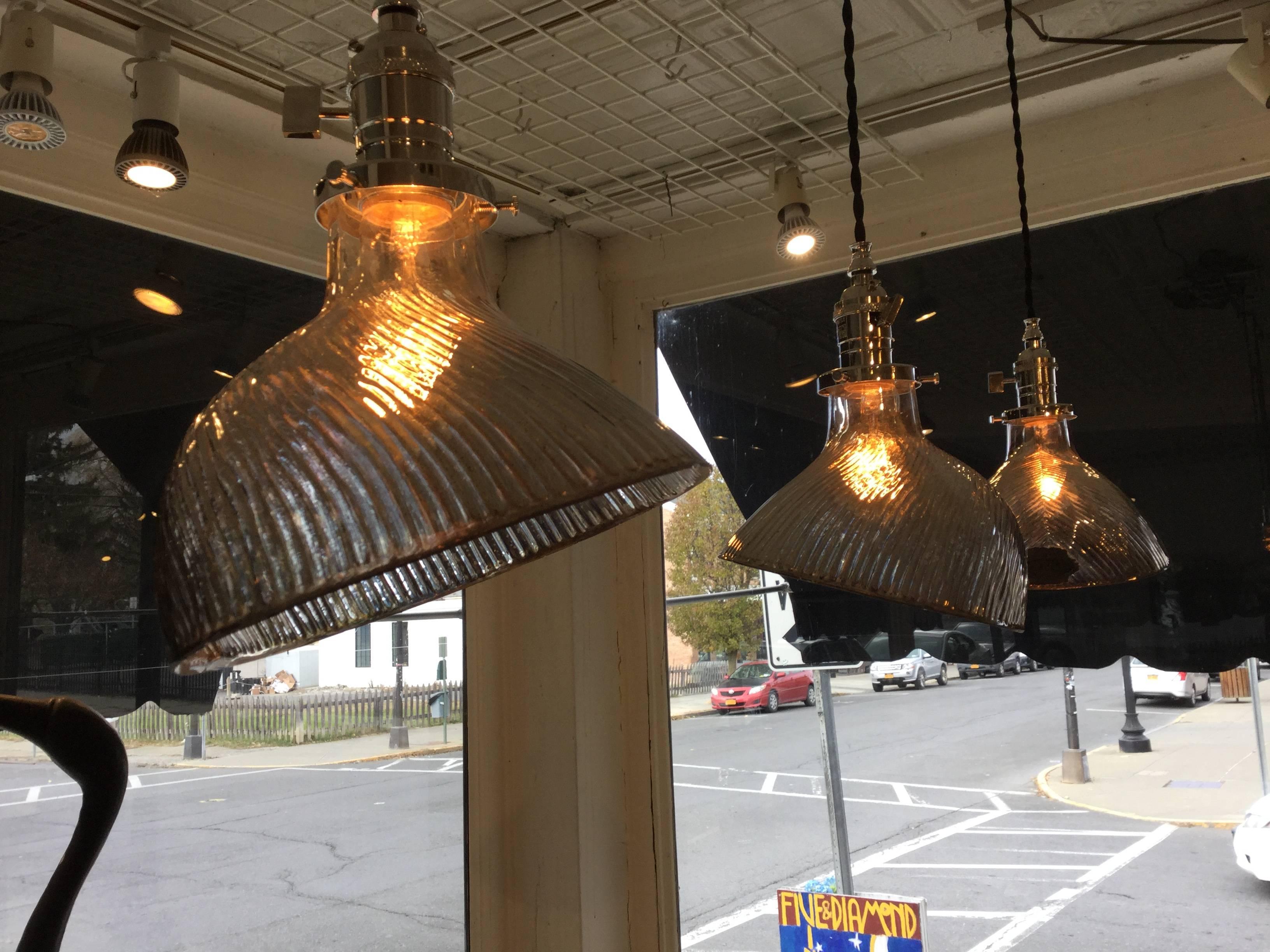 Four Mercury glass industrial pendant lights. The Mercury glass shades were designed to reflect the most light possible from the bulb. They were for industrial use in early factories. They usually has steel covers to protect the glass, but they are