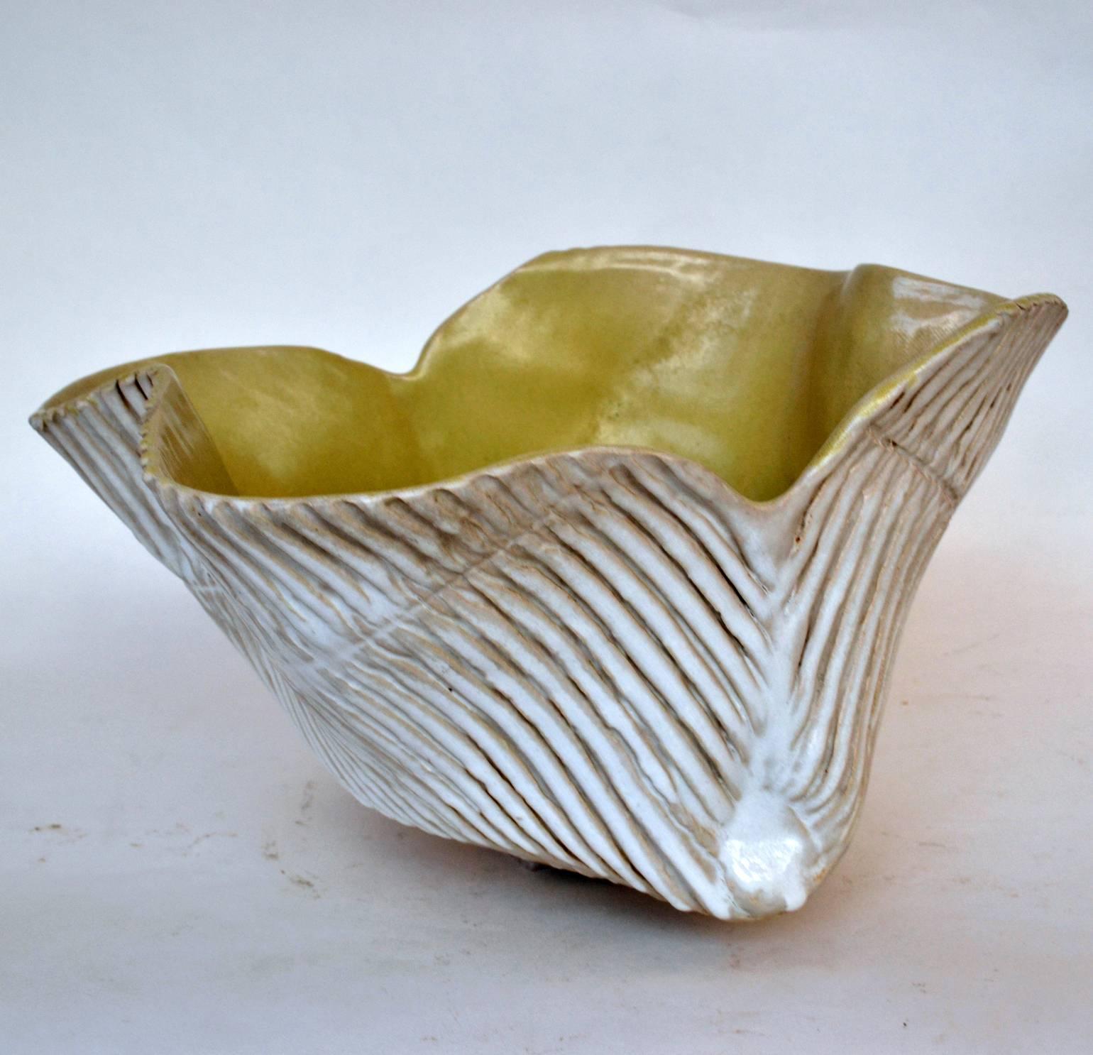 Organic hand formed bowl with ribbed outside is raised on a foot signed with the potters initials.
Inside the glaze is a pale mustard yellow.