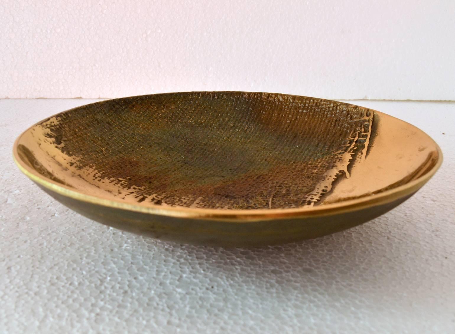 Artistic dish or bowl with the texture of burlap imprinted in part of the dish contrasted with a high polished sheen. The plate is part of a group of high quality cast items we present signed by Antonella Caprio Saviato made in the 1970s.