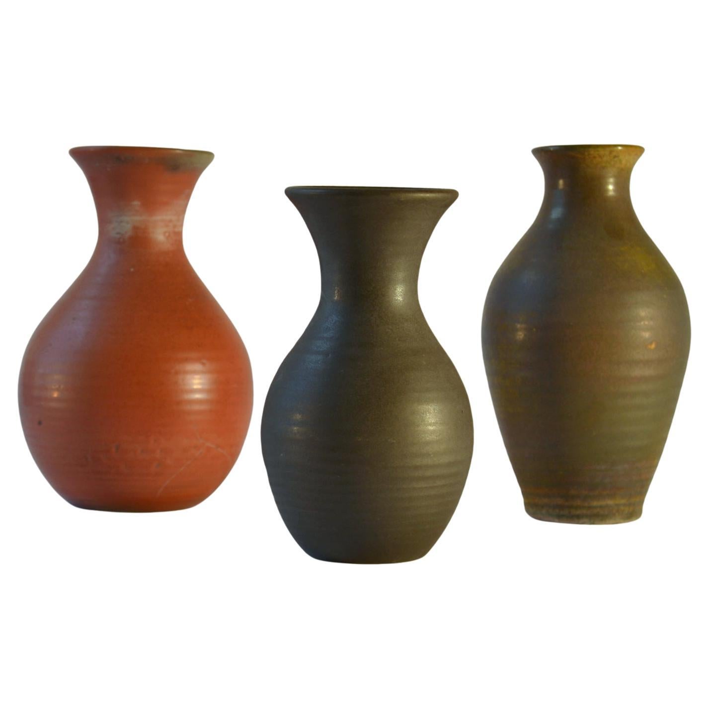 Three Studio Pottery vases in coral red, mat black and moss green are created on the turning wheel by highly technical skilled Dutch ceramist in the 1960s, made by De Olde Kuyk (DOK) Milsbeek, The Netherlands. The glazes in colours and textures from