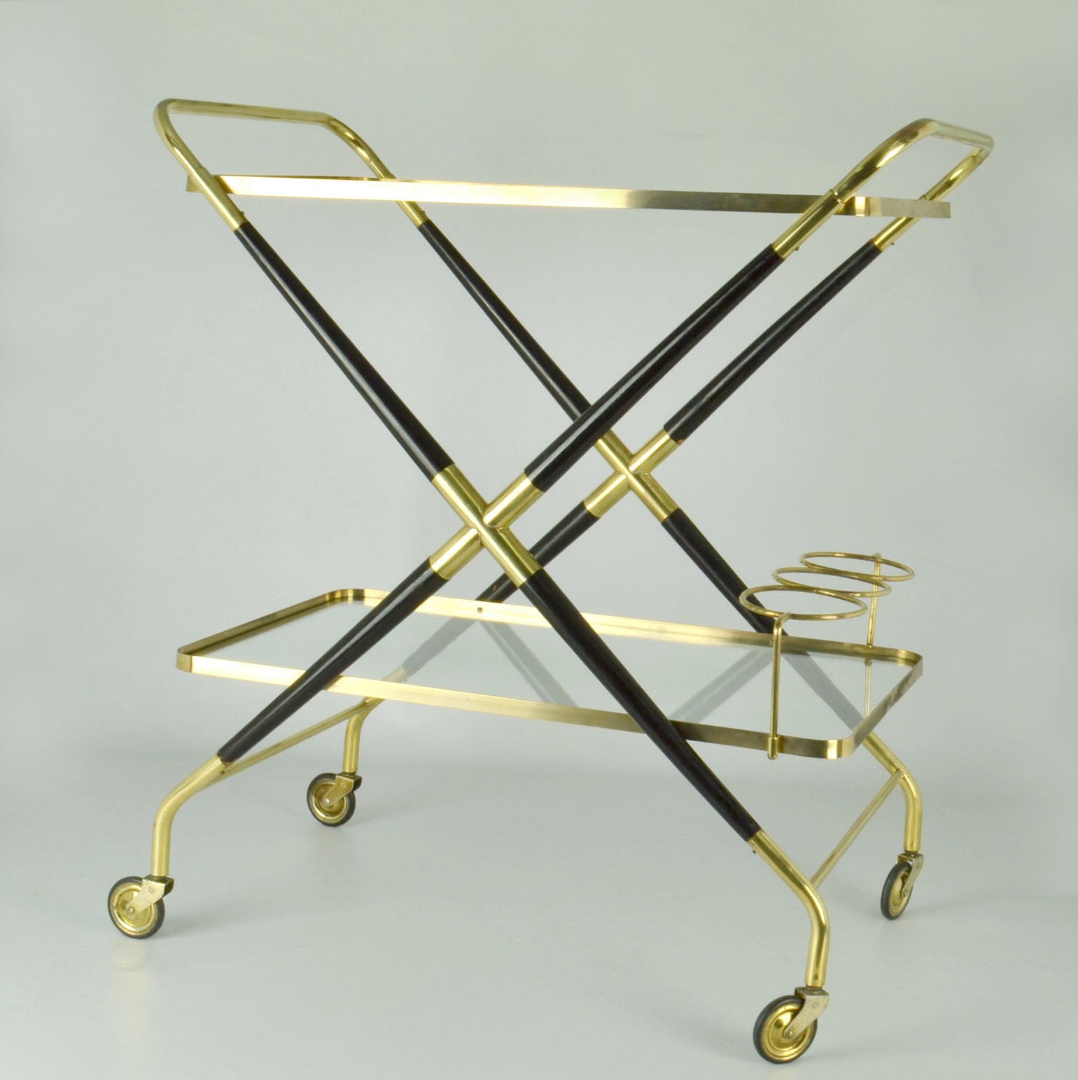 Stylish modernist bar cart or cocktail trolley by Cesare Lacca, Italy 1950's in brass and ebonized lacquered ash. Striking profile and sculptural look, featuring a lower level bottle rest and two levels of removable glass.