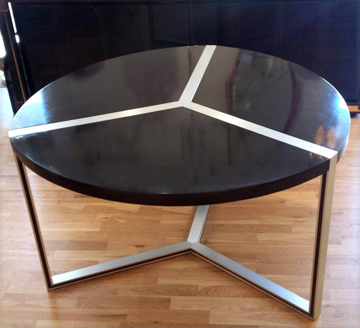 Six-seat dining table in hand polished dark brown stained teak and a brushed aluminum frame. The top is divided in three sections. The aluminum frame is inlaid with a strip of teak veneer.