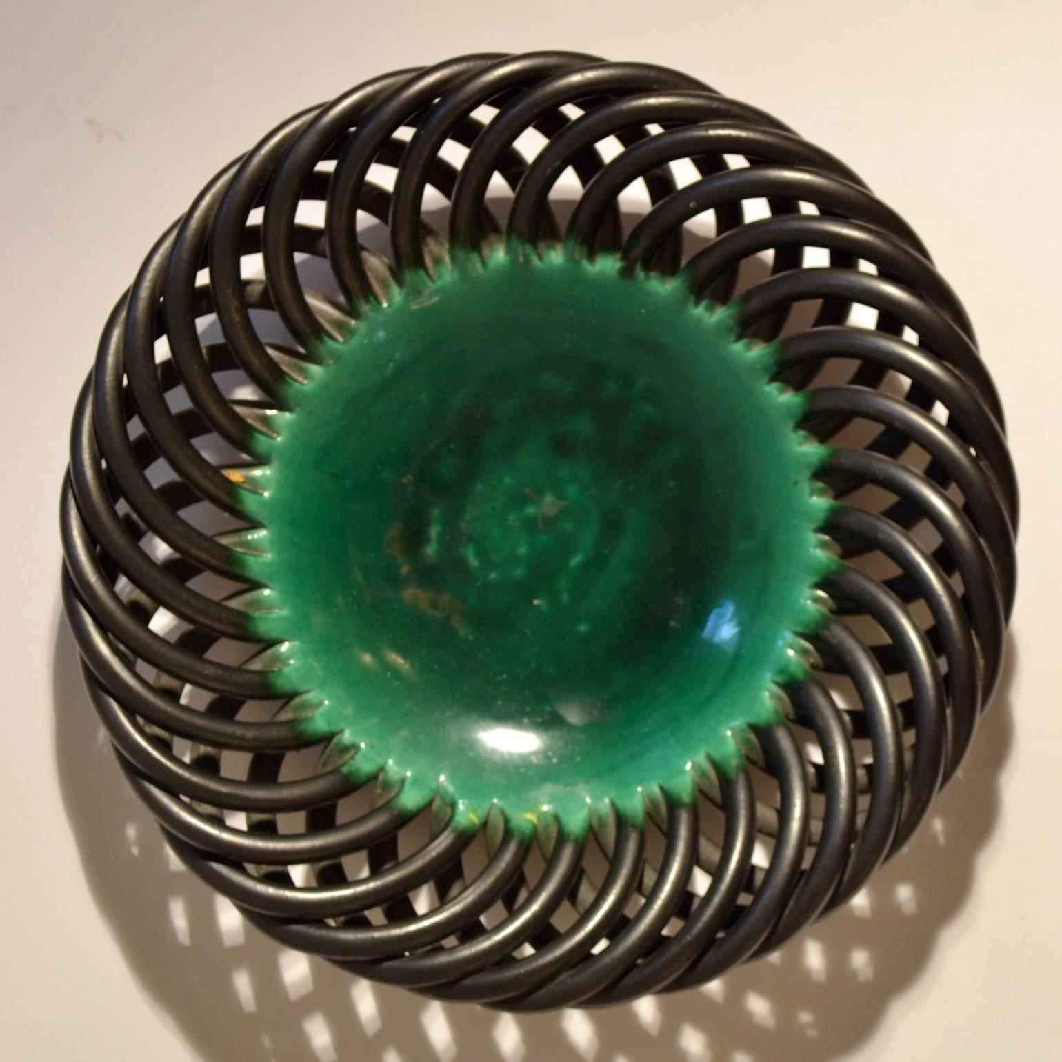 Sculptural formed ceramic, French, 1950s fruit bowl in the style of Jerome Massier, Vallauris with an embossed signature.
The dish has a central shiny emerald green glaze, edged with twisted strings in a graphite color satin glaze.
  