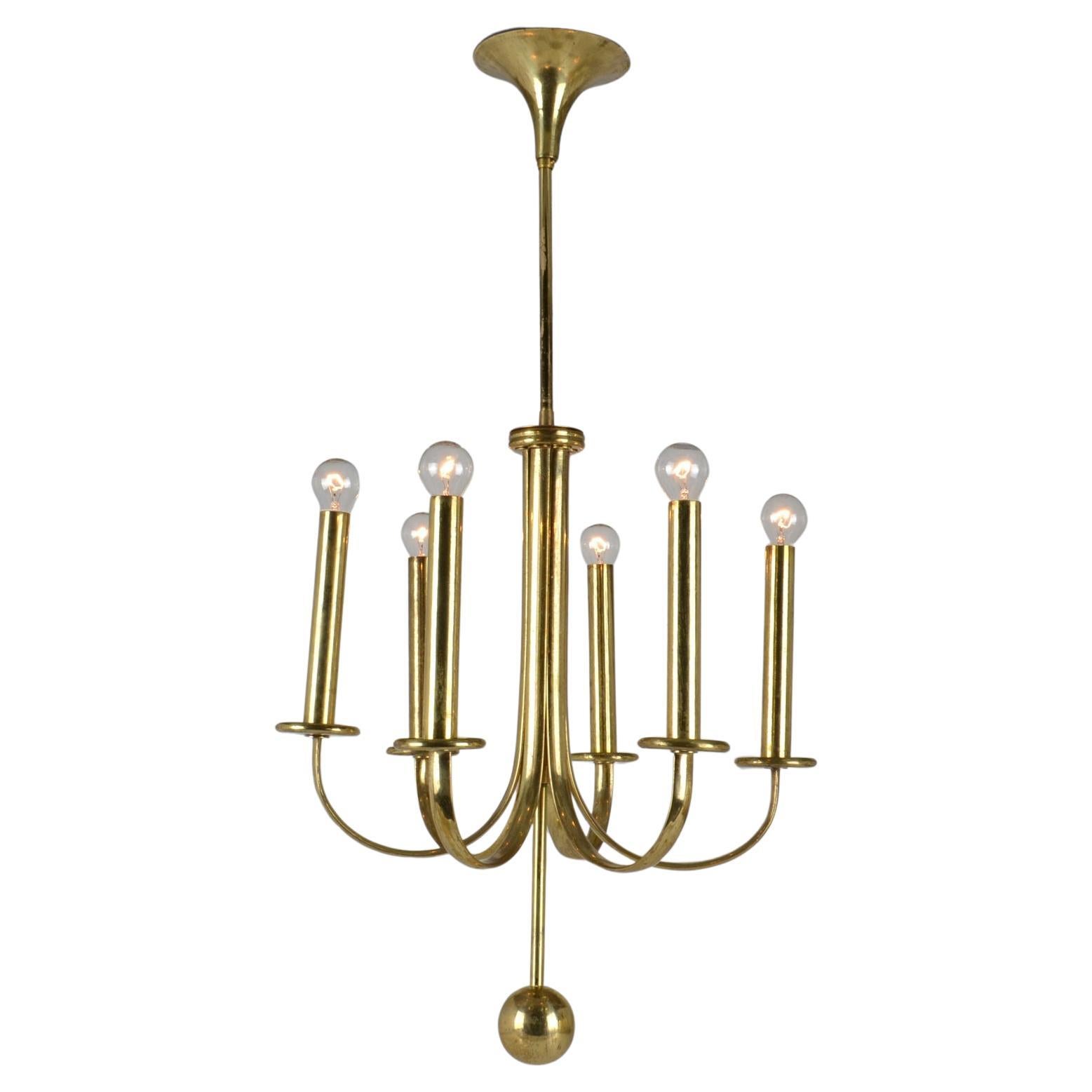 Elegante lampadario a sei bracci in ottone dai contorni minimali e dalla patina originale.