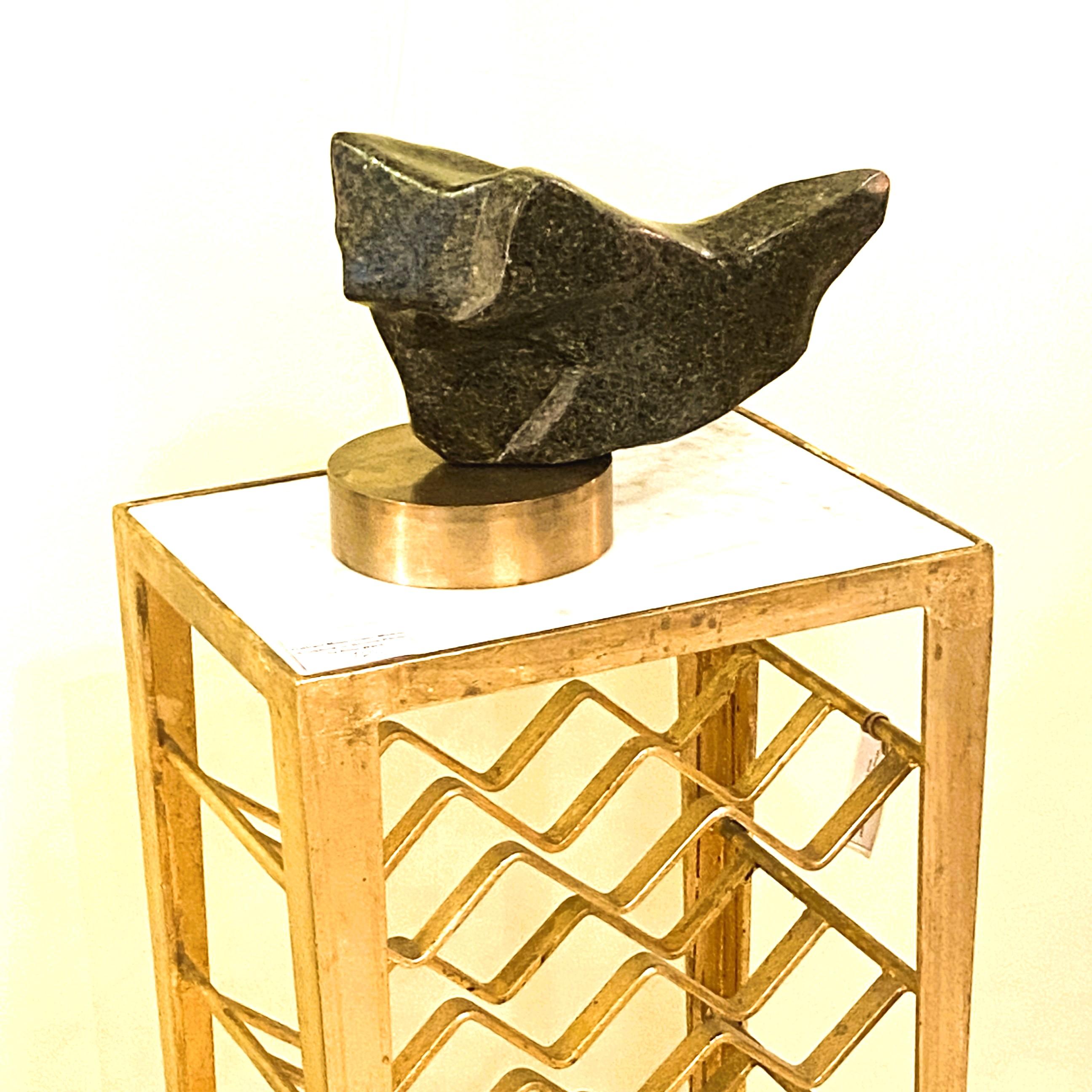 Hand-carved sculpture in moss green marble / granite on a polished round bronze plinth by the late Alice Ward. Her sculpture echoes a voyage of discovery in not just the visible natural world of rocks and landscape with her exploration of space and