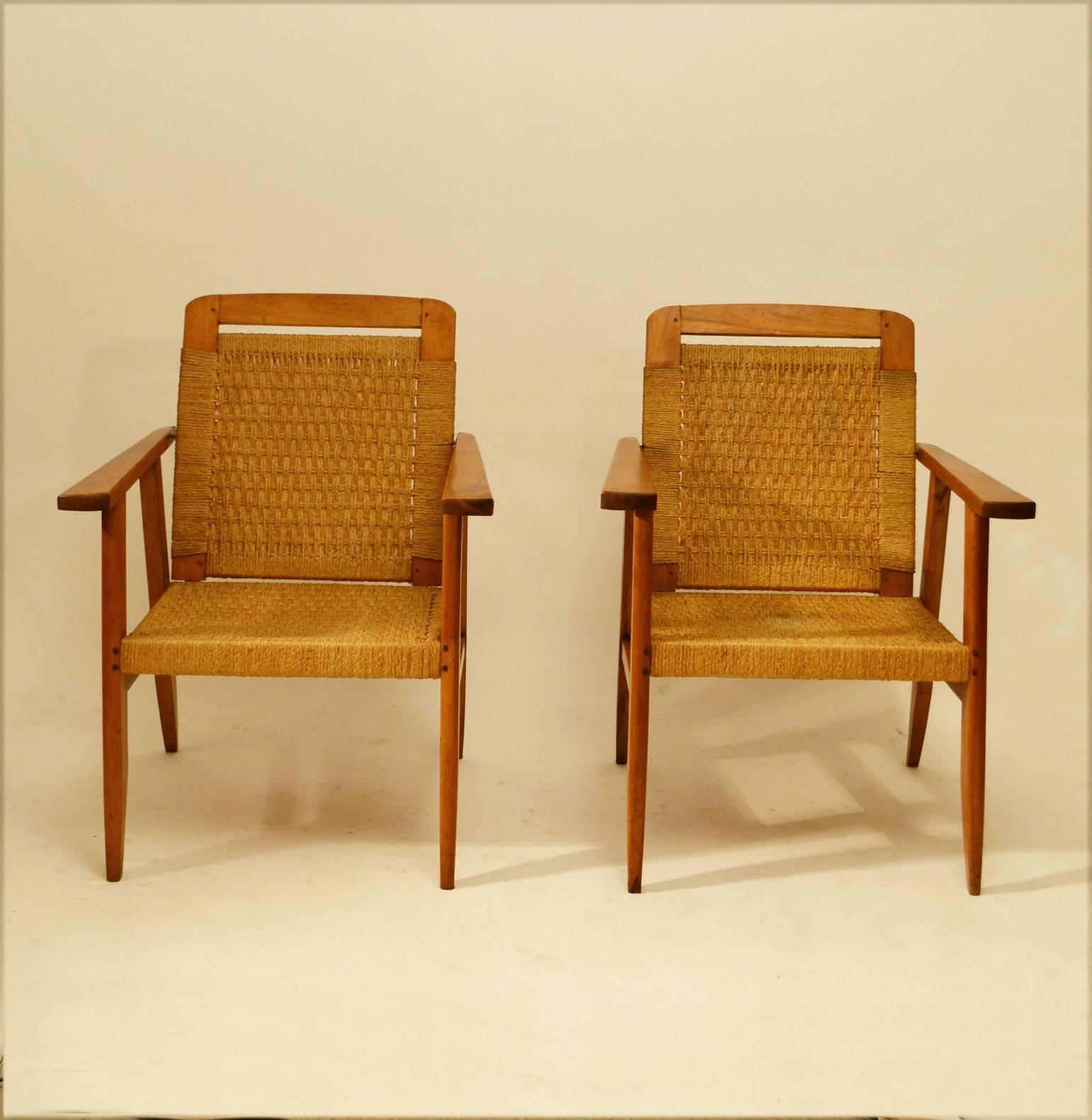 Modernist design of oak frame chairs with woven rush seat and adjustable swivel back.