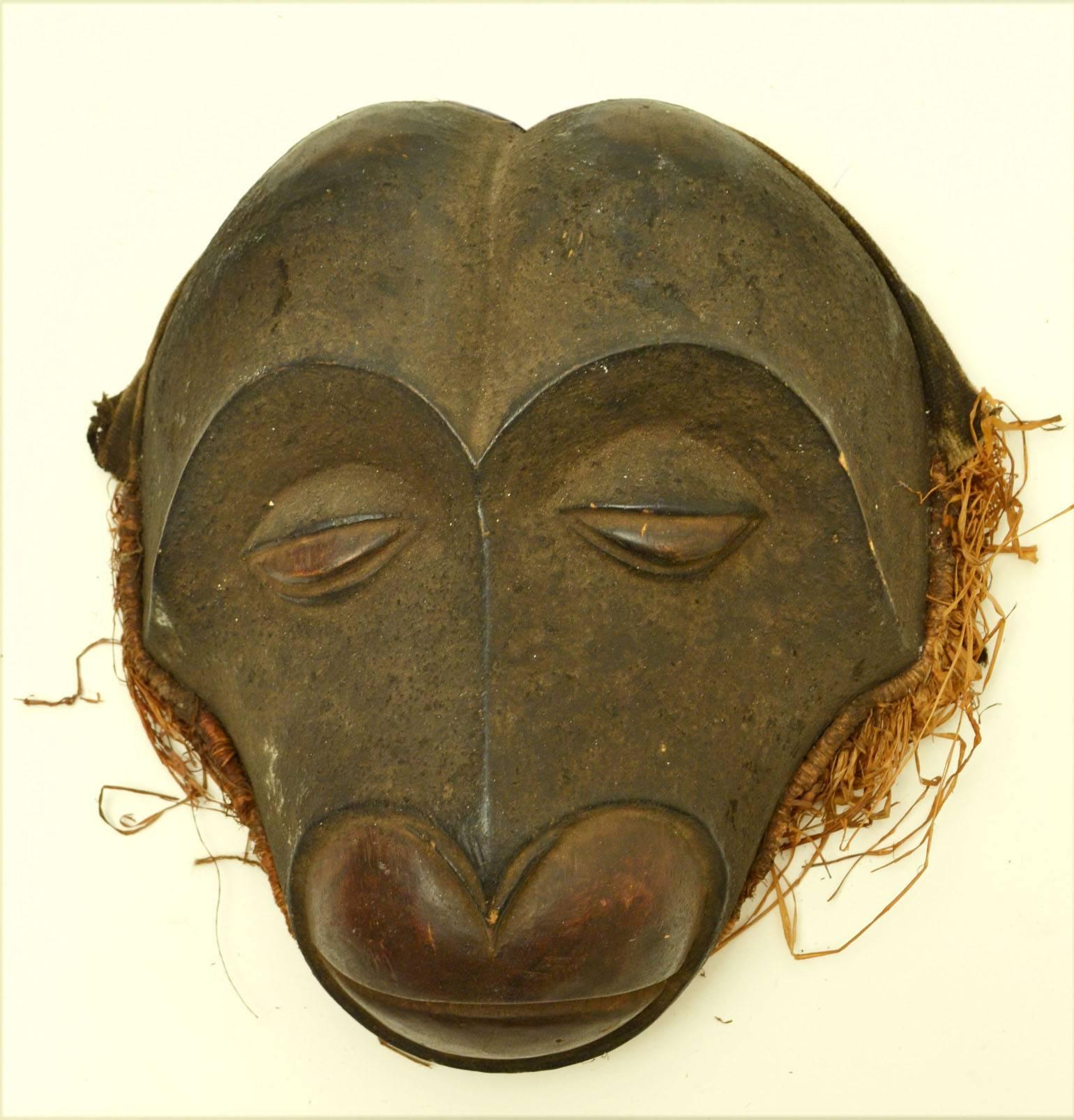 Original dance masks from the region of Cameroon and Congo carved in wood and edged with raffia.