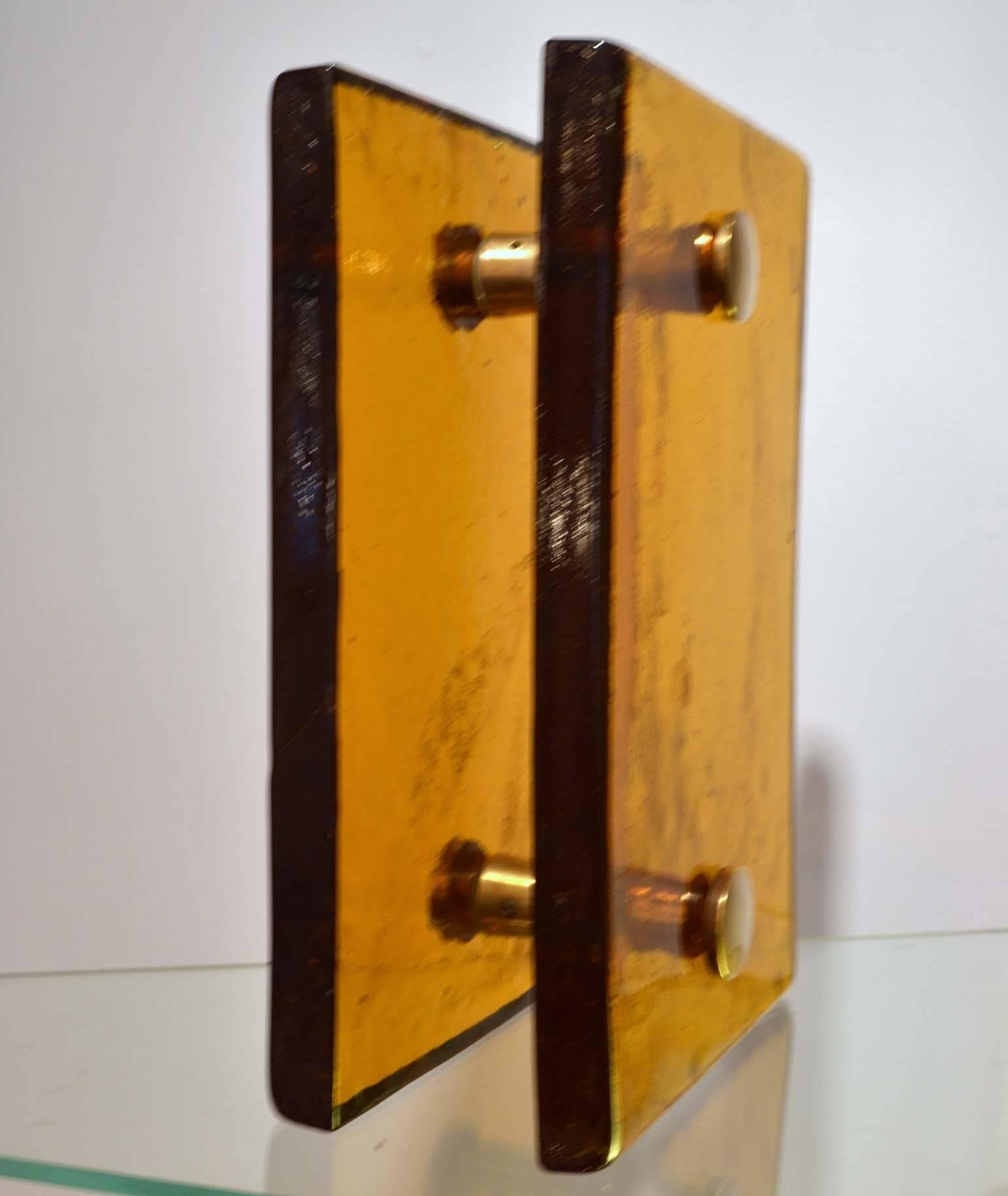 Amber glass double door handle with brass fittings for a glass door. France 1960-70's
They can be adapted for a wooden door by extending the external thread.
The last picture shows an orange pair that is available.
