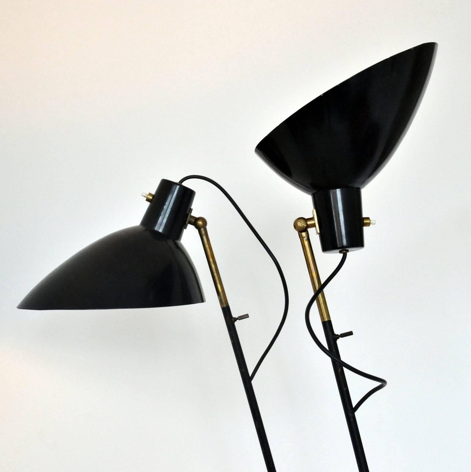 Elegant black metal floor lamps with a typical 1950s streamlined modernist design. The shades are are fully adjustable and function as up or down lighters.

   
