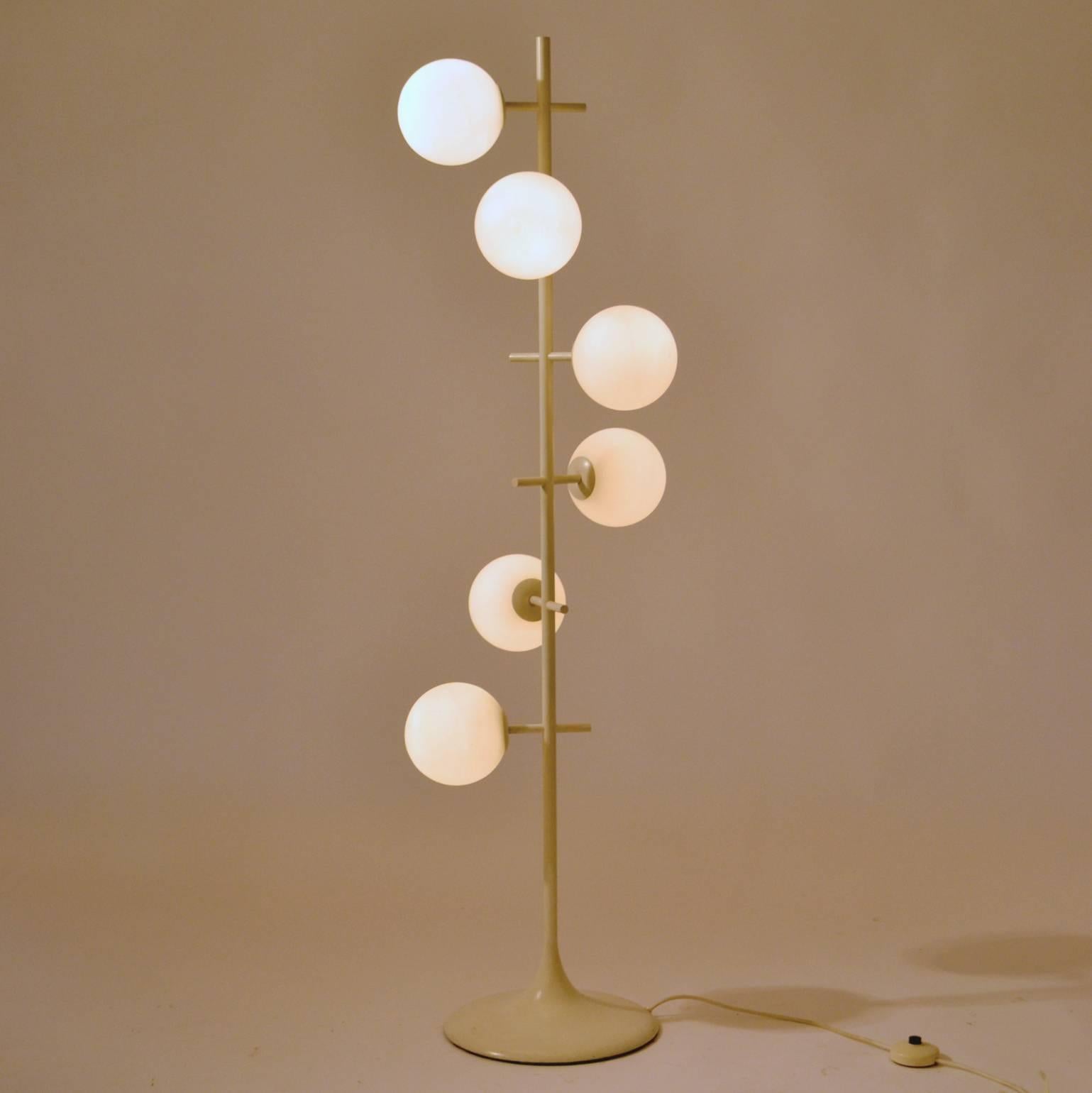 Minimal 1960s floor lamp in the style of Max Bill, manufactured by German-Swiss lighting manufacturer Temde Leuchten. Six opaline handblown globes radiate around the white enameled metal central column with a tulip foot. 
The label reads “Temde