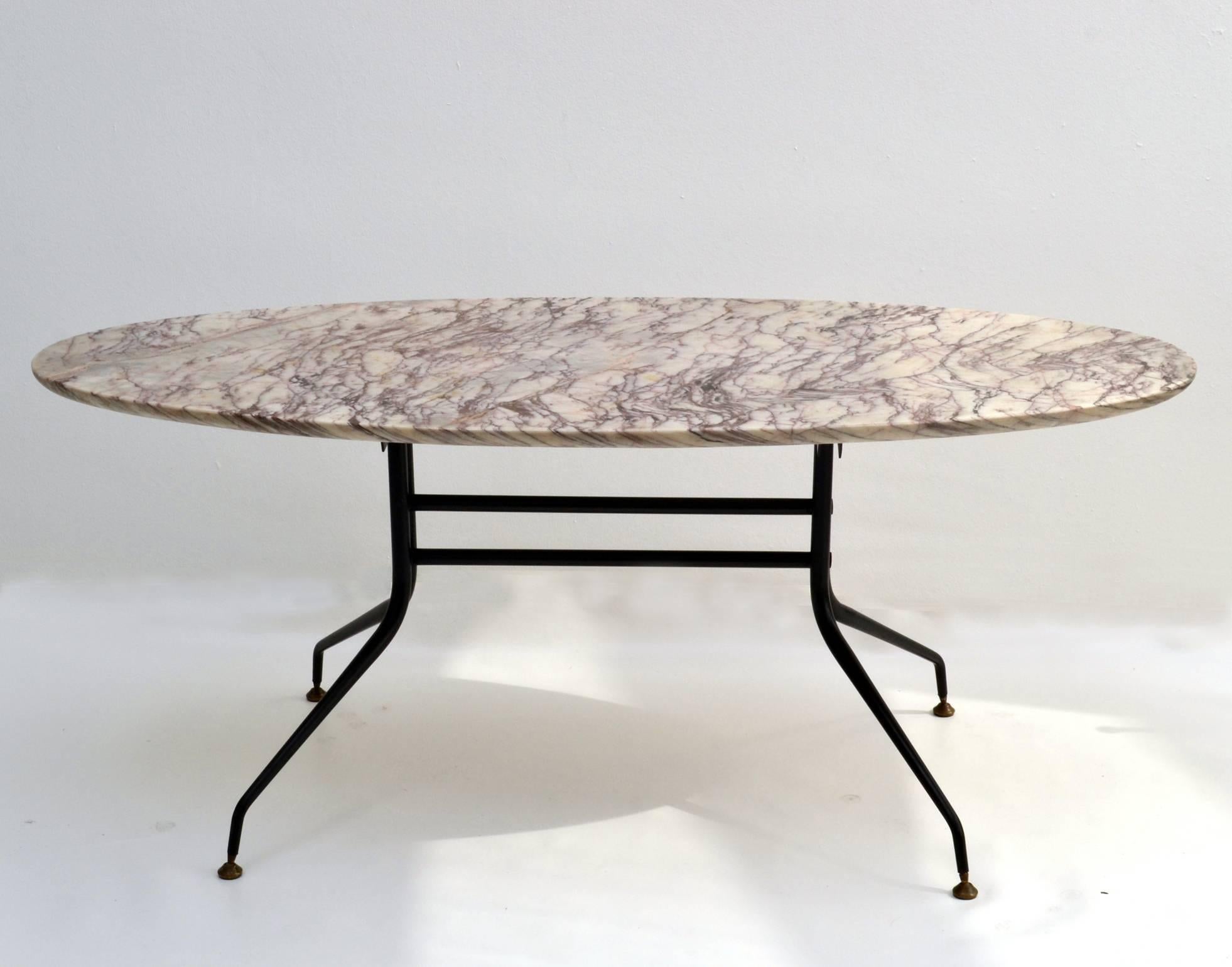An exceptional 1950s Italian elliptical coffee table consisting of an long oval 'surfboard' shaped purple vein white marble top supported by elegant spider legs on brass feet.