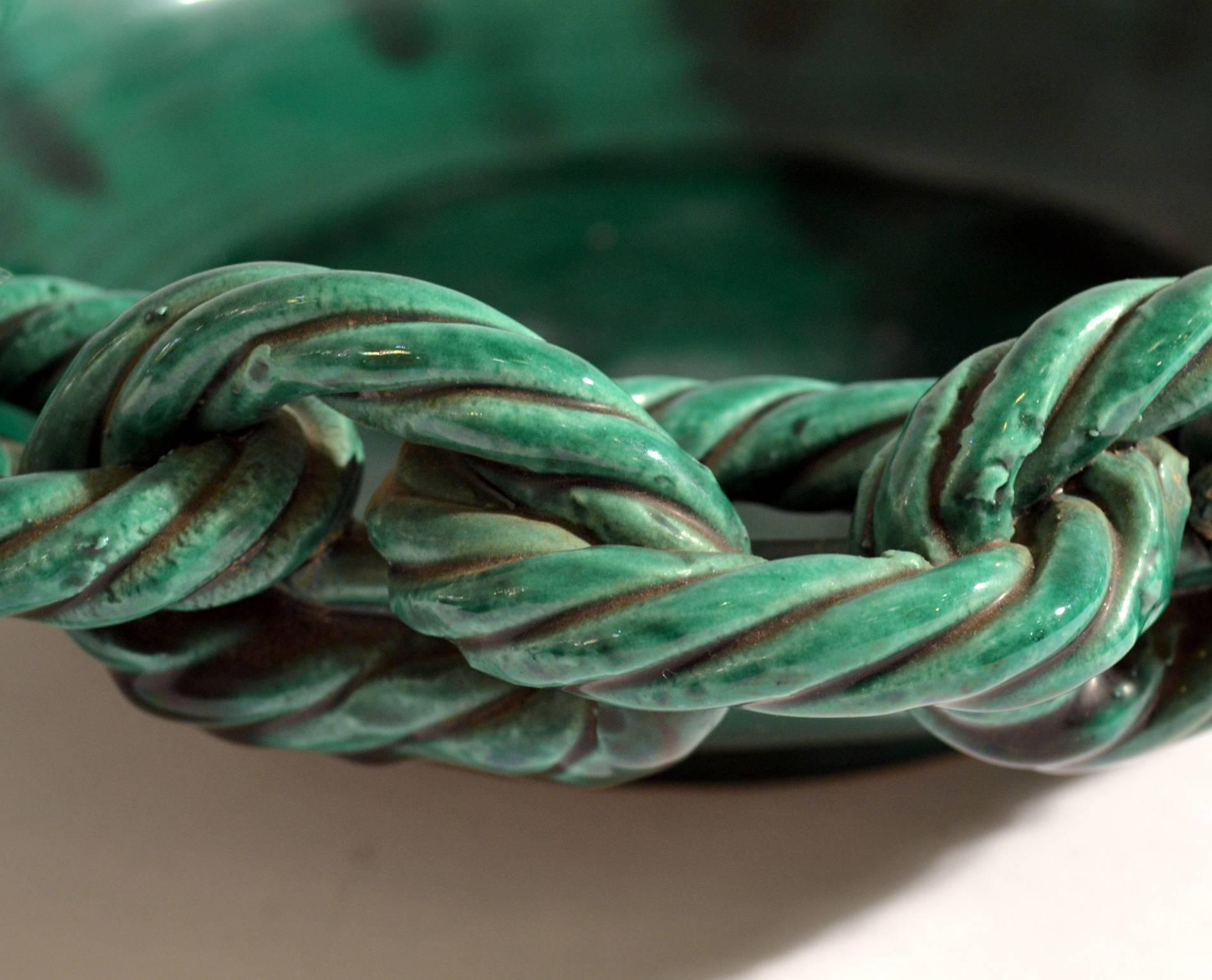 Hand formed emerald green glazed, French, 1950s fruit bowl signed Vallauris, decorated with a ceramic rope chain around the edge.
There are several models available, See image 8-10.