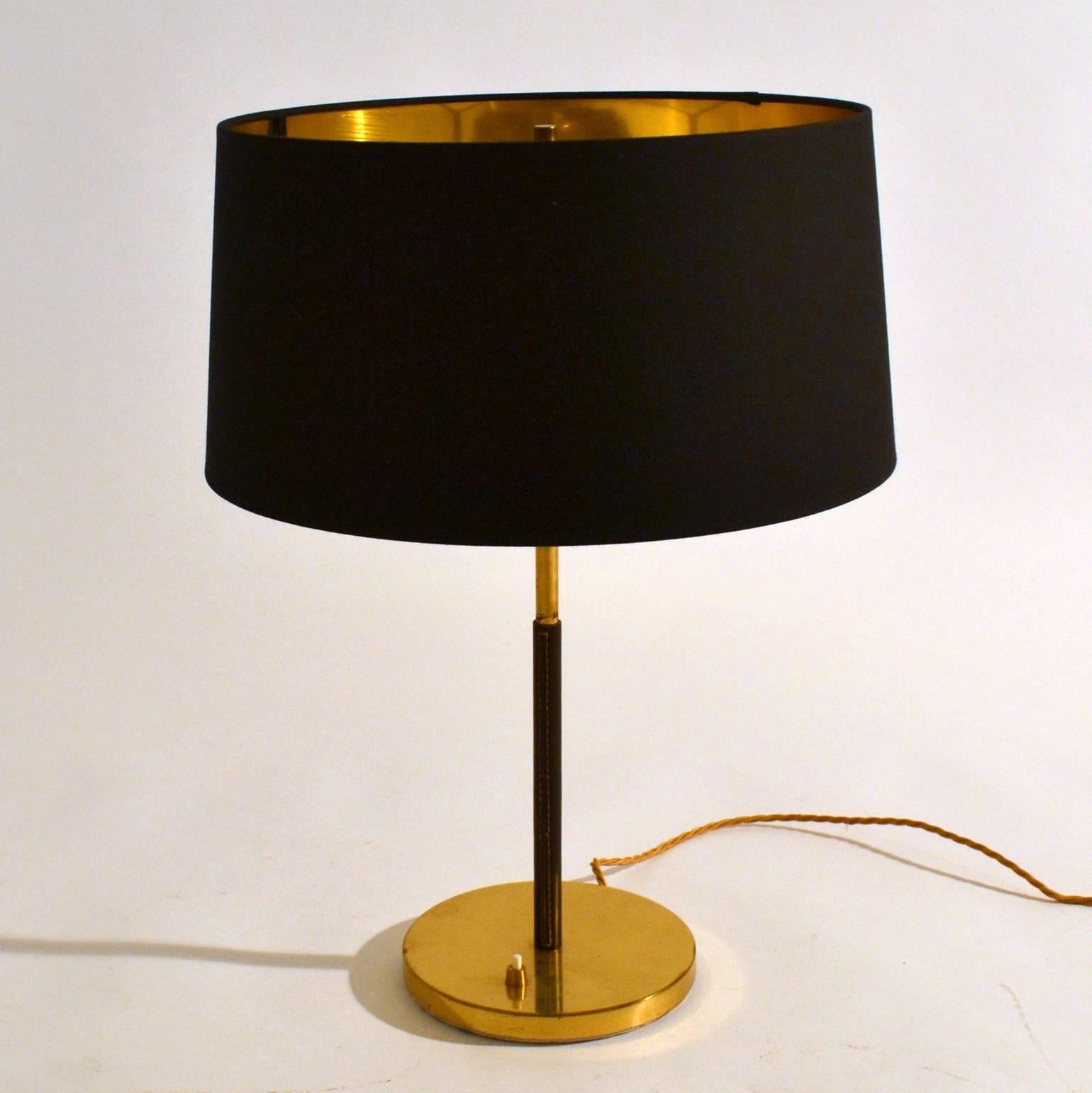 Pair of stylish Kalmar brass table lamps with leather covered stem and a heavy metal base. The black and gold lampshades are new.

Bases are in a perfect and fully original condition. A large stock available.
The lamps are rewired and ready for