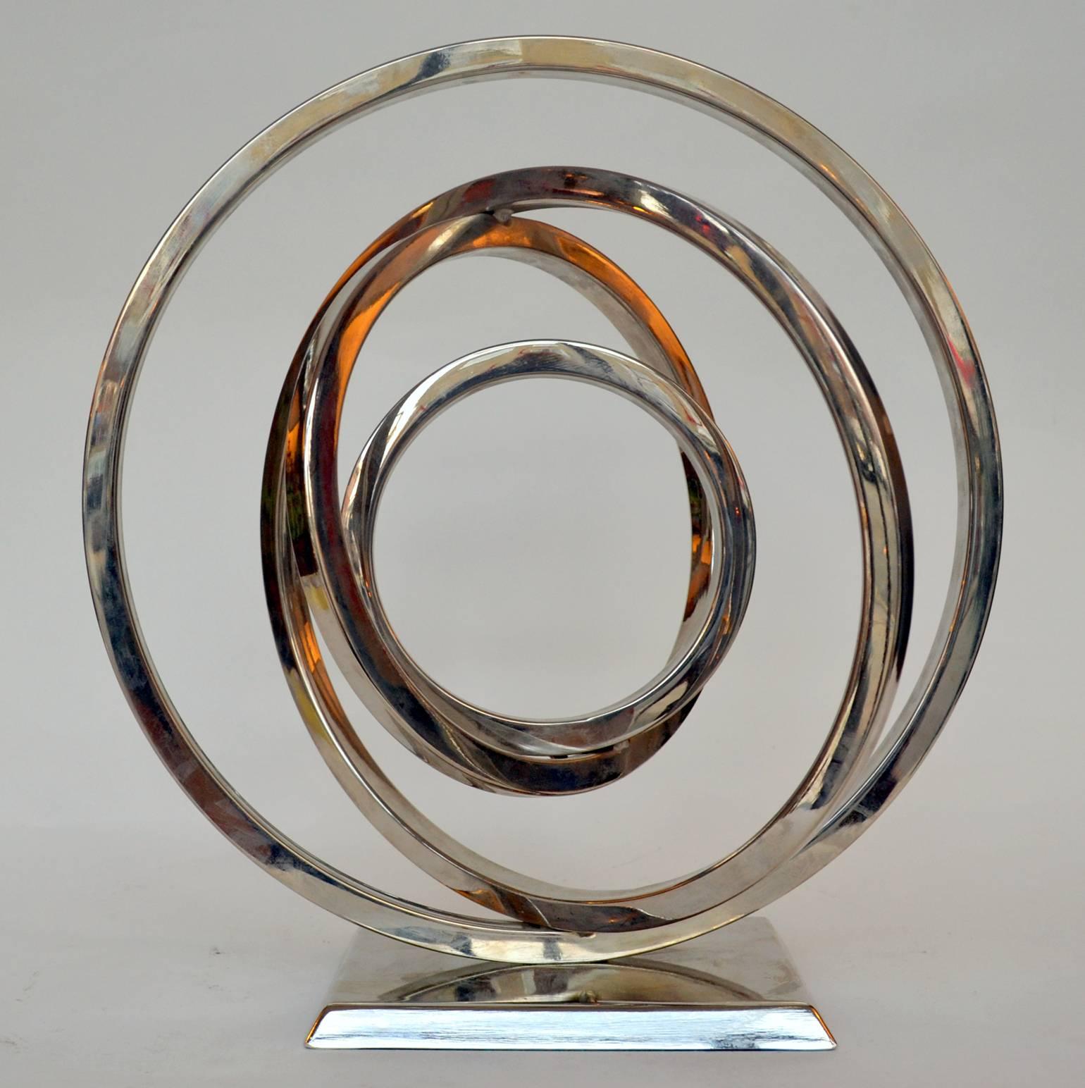 Atomic shape sculpture constructed in square tubular rings in chrome metal.