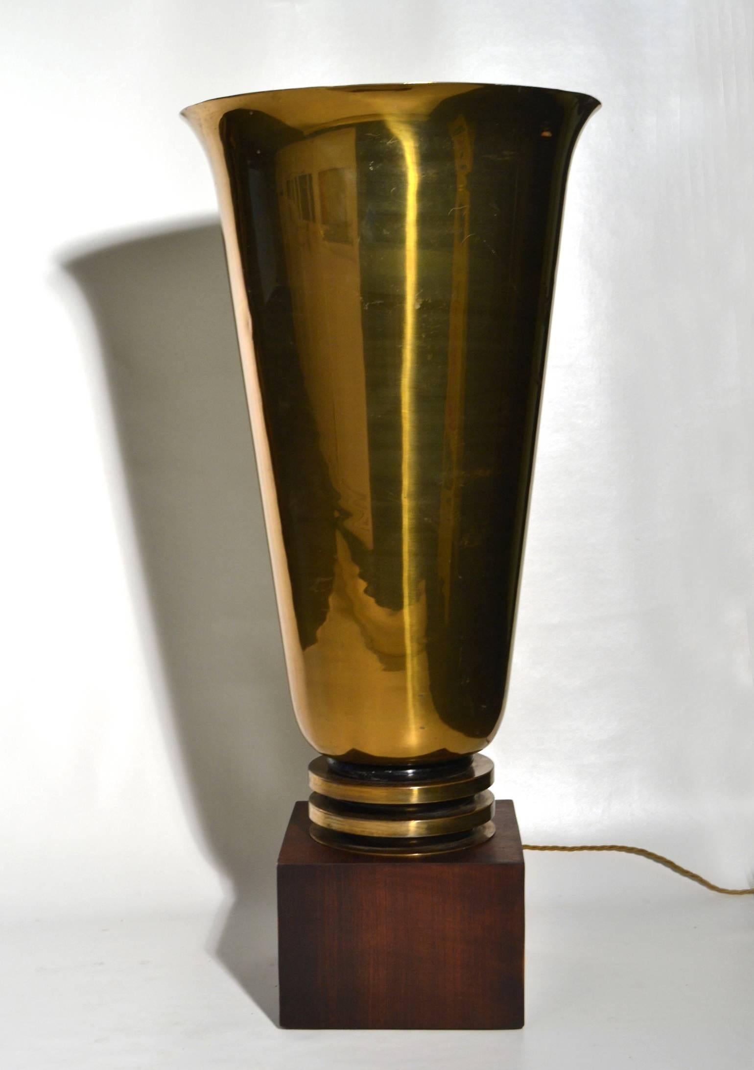 This powerful uplighter bell shaped torch lamp body is of polished brass on Magasar wooden base. The lamp would originally been placed as a centrepiece in a hallway, a stairway or on a table.
 French tabletop torchiere gleams as the polished brass