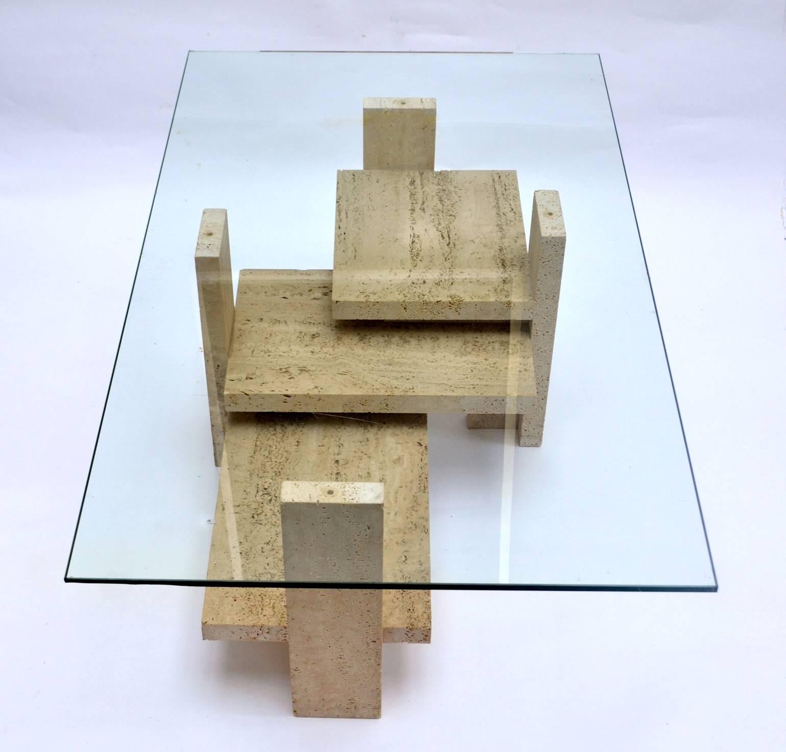 Cubist style coffee table base is build in blocks of travertine. It's form changes from every perspective you see it. #
Designed and hand crafted by Willy Ballez, Belgium 1970's.
Dimensions glass top : 120 x 65 cm 
Thickness glass; 15 mm 
Dimensions