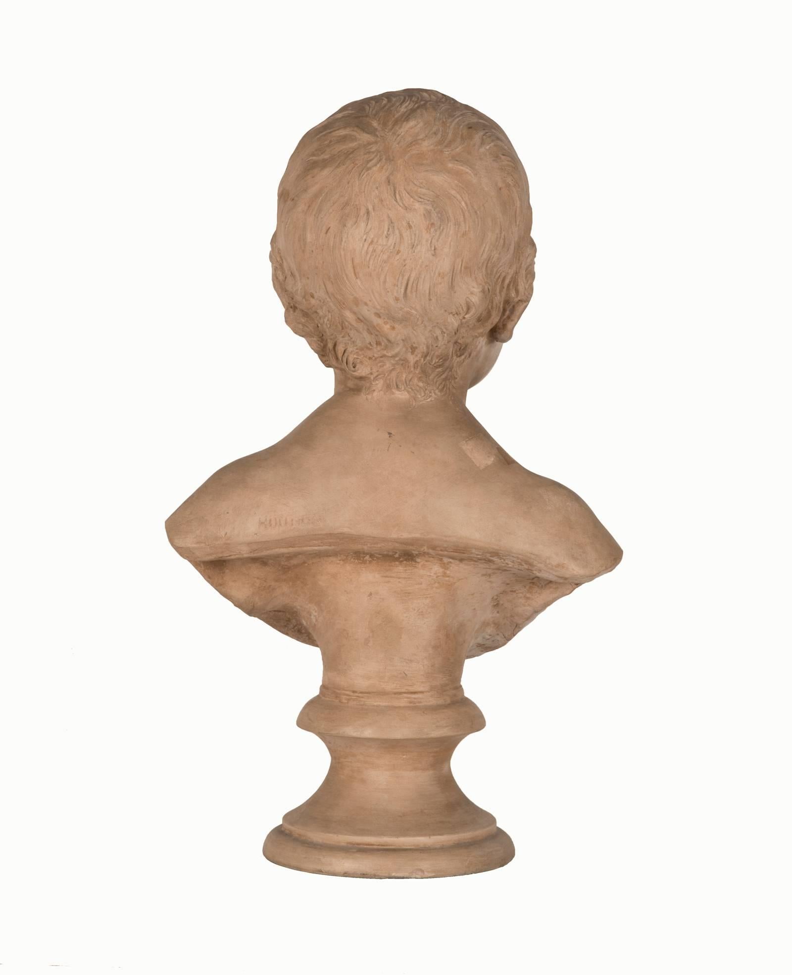 An expressed innocence is naturally depicted in this terracotta bust of a young child, the tender modelling exemplifying Houdon's sensitivity to the subtlest expression of features. The bust ends in rounded truncation and sits upon a round Louis XV