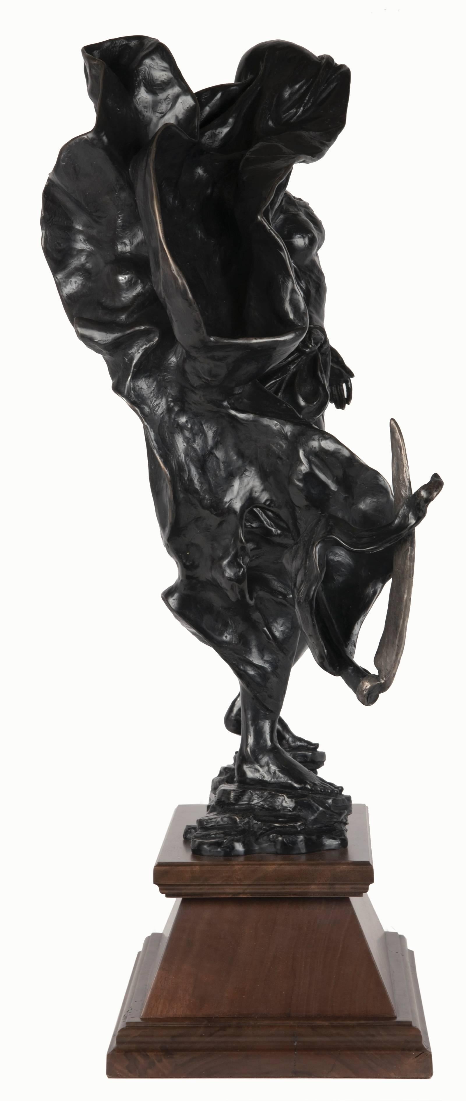 Standing in a state of observance and anticipated movement on a ground of rock, confidence and power exude from this figural sculpture. This sense of stability in direct contrast to the display of movement and emotion as seen in its billowing