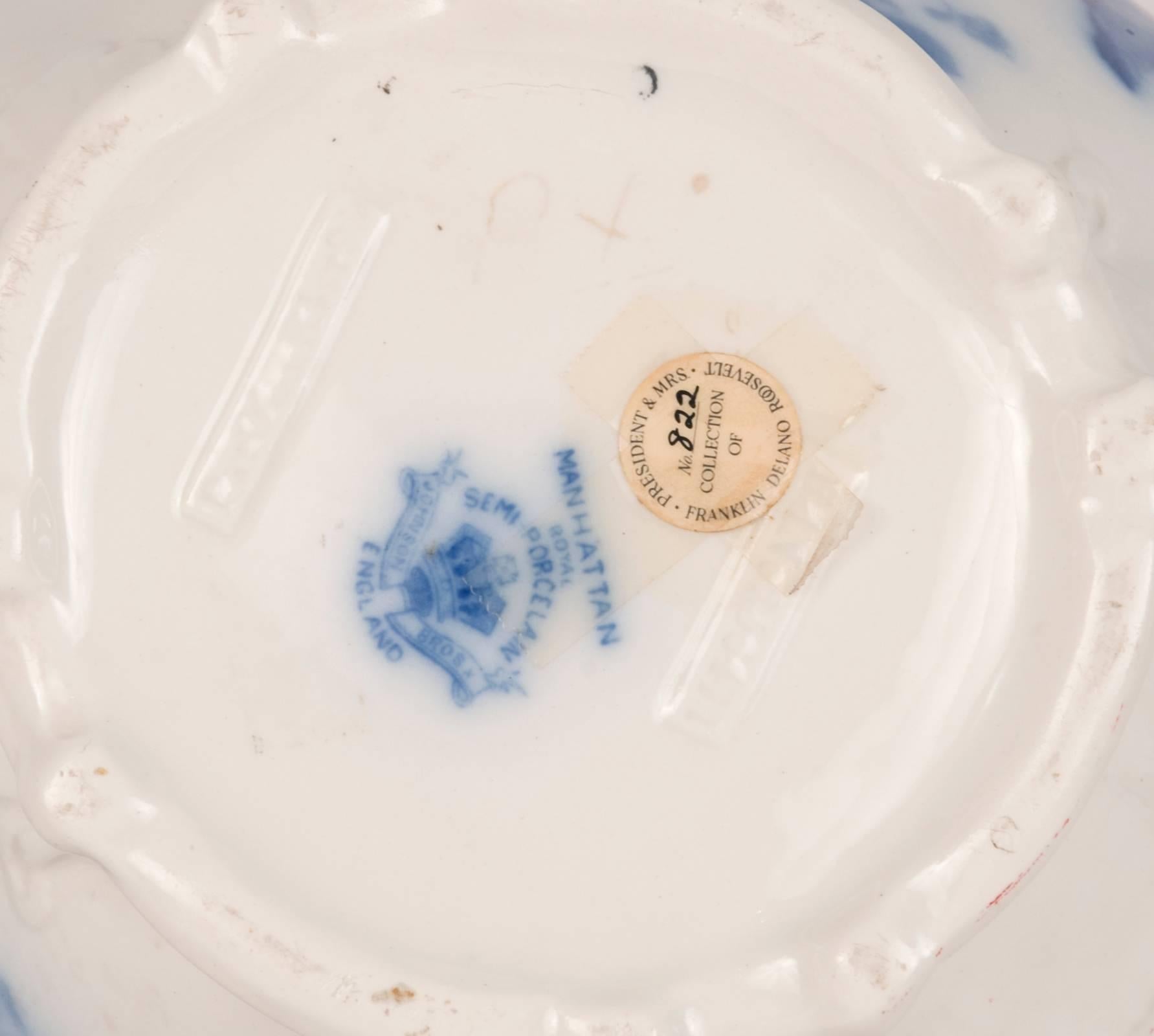 Delicately painted floral and vine pattern in deep cobalt blue on the ornately shaped bodies of this wash bowl and pitcher set, the under glaze flow blue enhanced by the embossed details of the porcelain, circa 1900.

The base of the bowl is