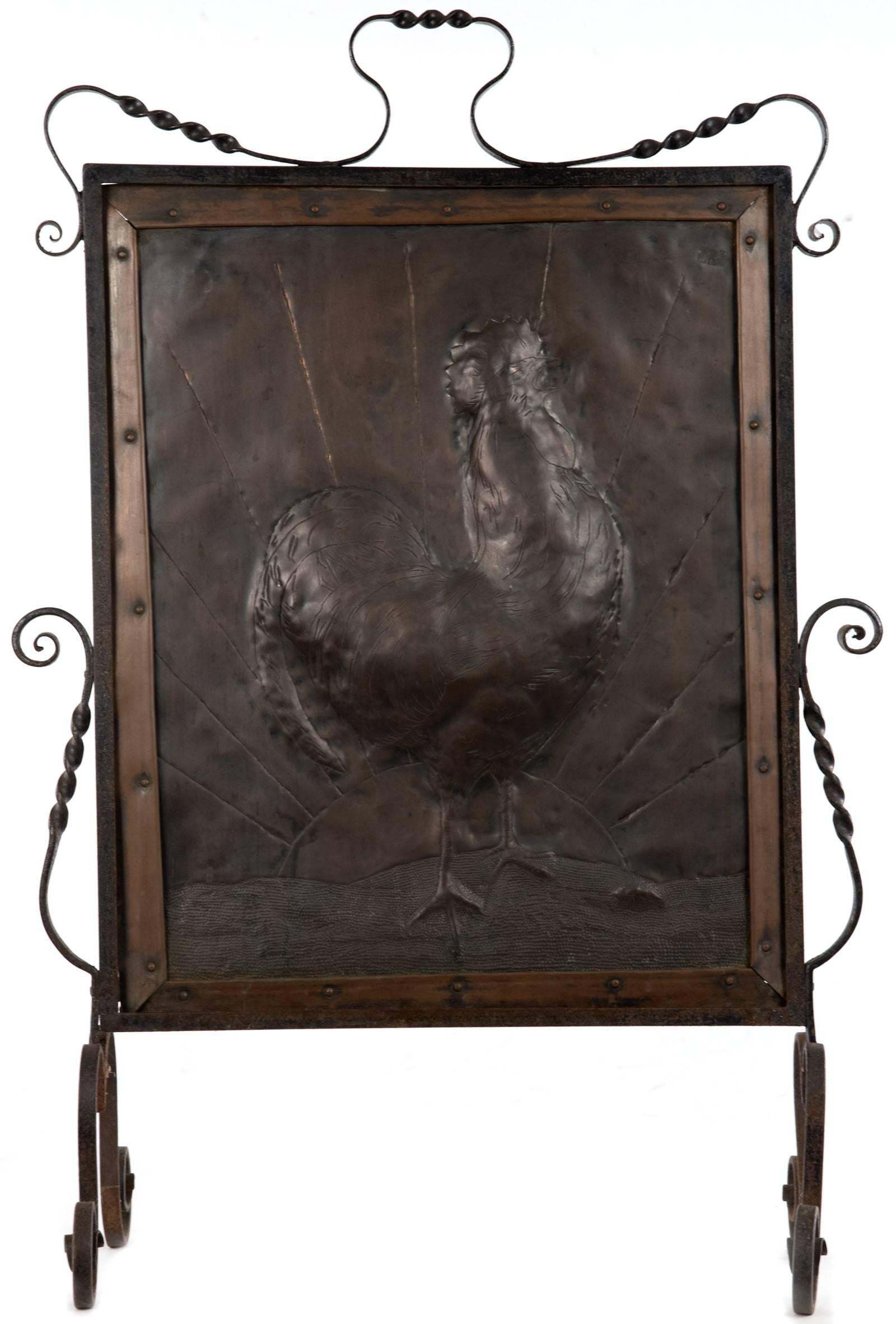 A solid copper plate featuring a repousse cockerel with hand-chased detailing against a chased image of a rising sun and hand-hammered dimpled texture ground. The copper image is encased in a copper frame, within a wrought iron scroll work stand.