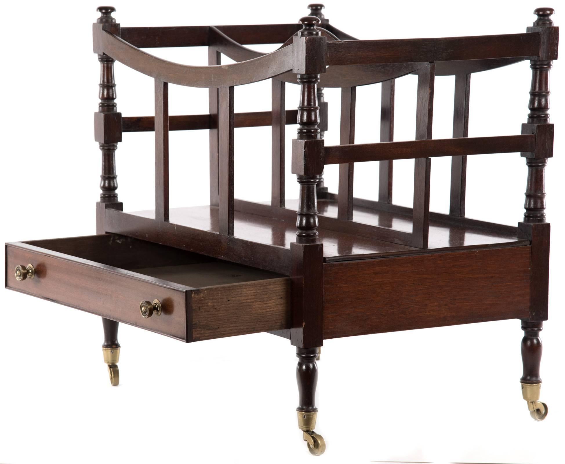 A 19th century Regency period zebrawood canterbury of boat shaped form having pierced carrying handle and turned upright supports, above one drawer of dovetail construction with brass pulls and raised on elegantly turned short legs that terminate in