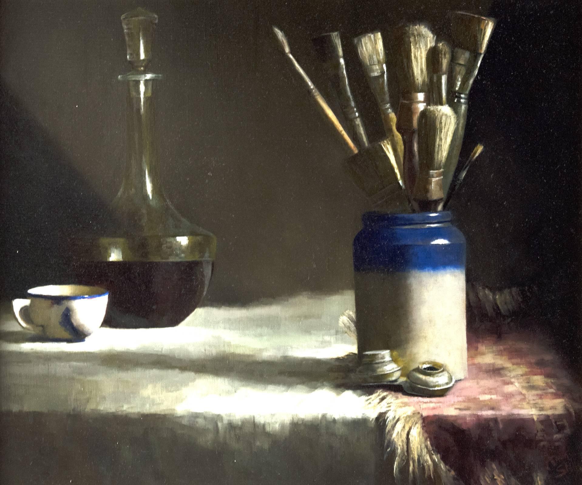 From just outside of the frame of the composition, a soft light shines down from the upper right corner onto a table, draped in a white cloth and gold-fringed oriental rug, that holds a small grouping of the artist's studio accoutrements. In the