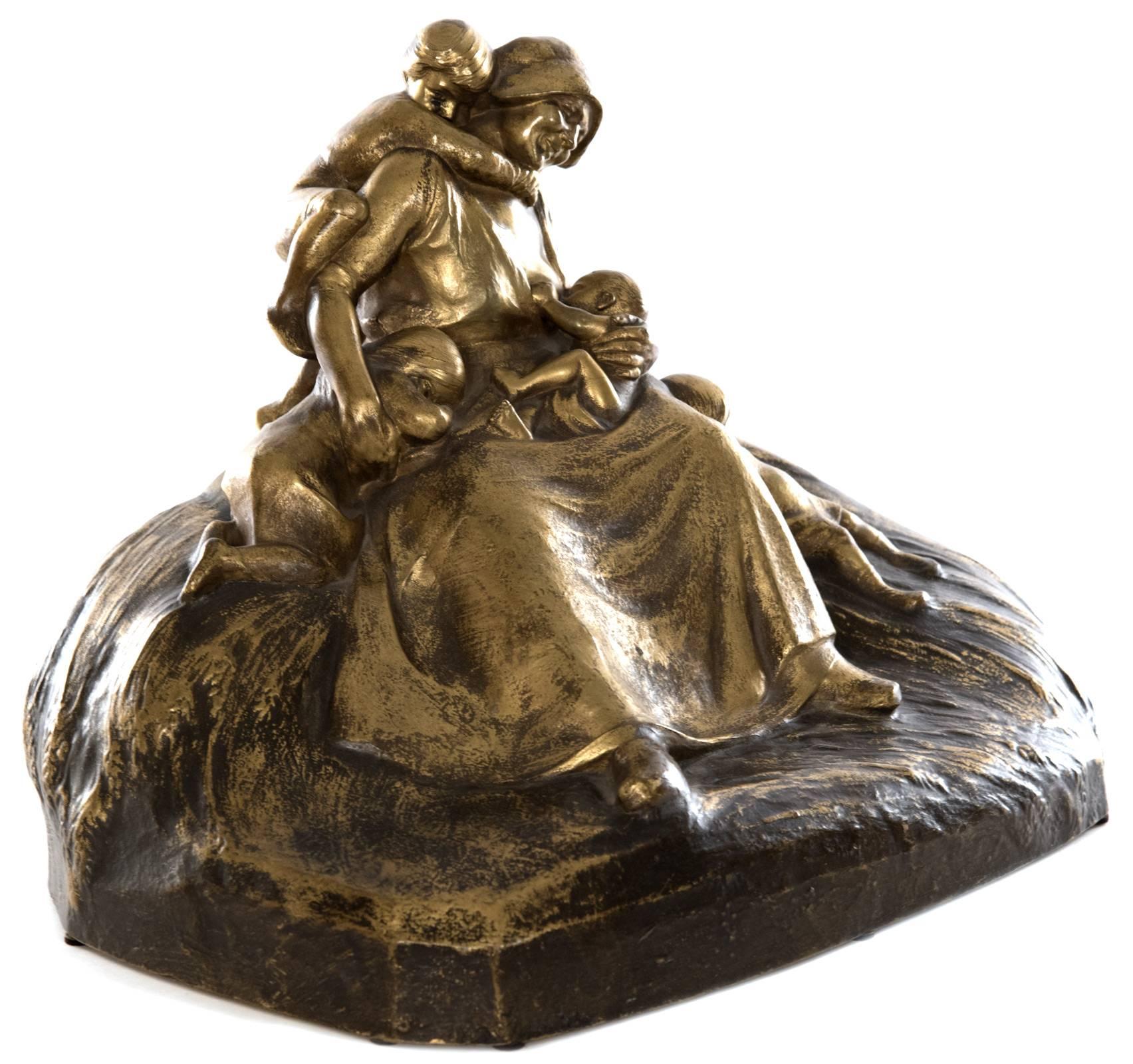 Lucien Charles Edouard Alliot (1877-1967) depicts a mother, exuding strength and love, at the centre of this figural bronze grouping, a smile captured on her face as she lovingly looks upon the infant feeding at her breast, while three young